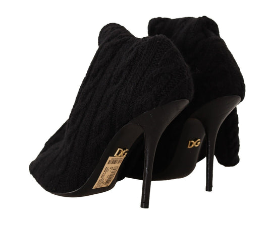 Pair of black suede high heel shoes with fur trim and gold lettering on soles