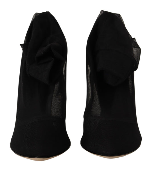 Pair of black high heel shoes with ruffled straps and a bow on top