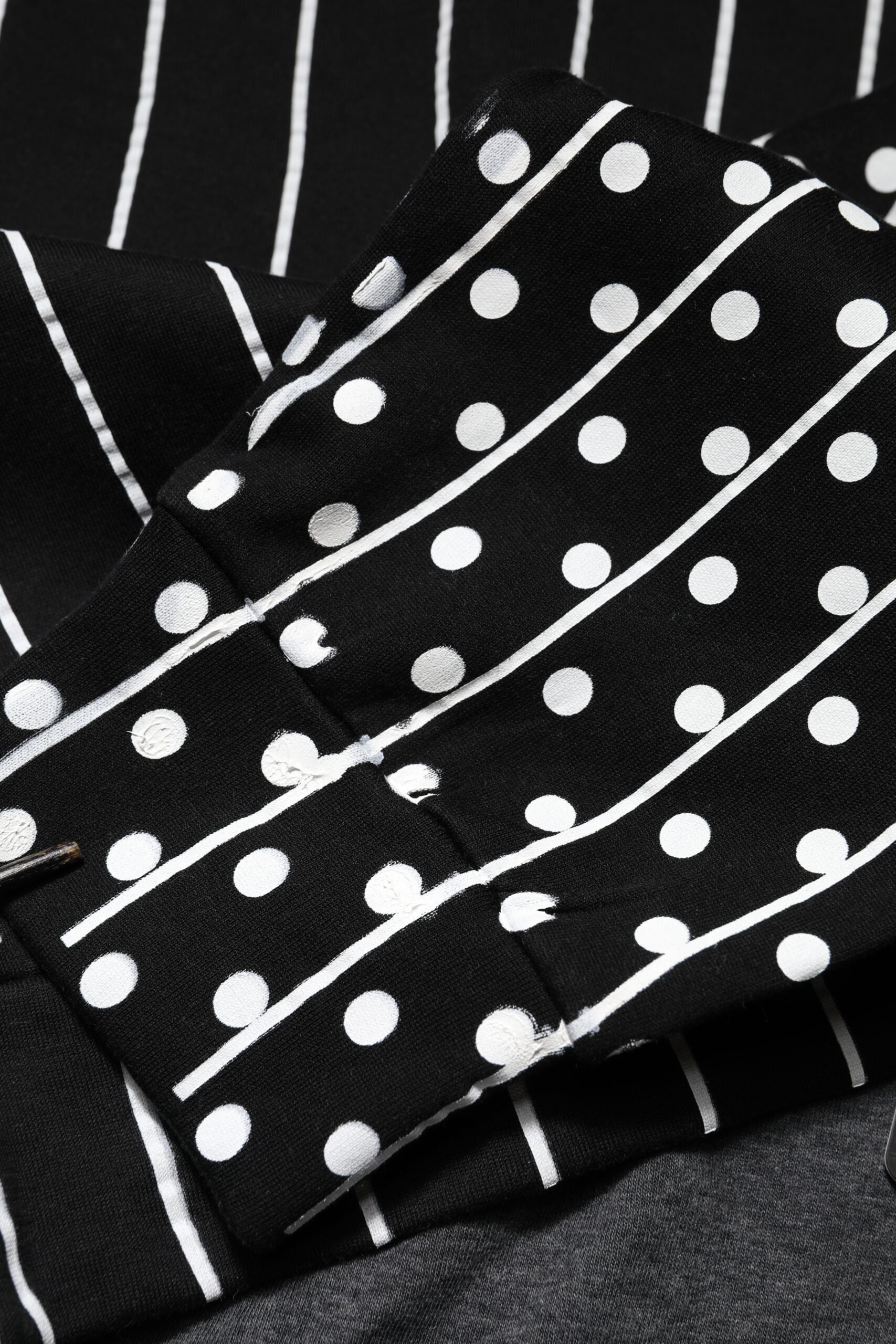Black polka dot fabric with white dots on a black background