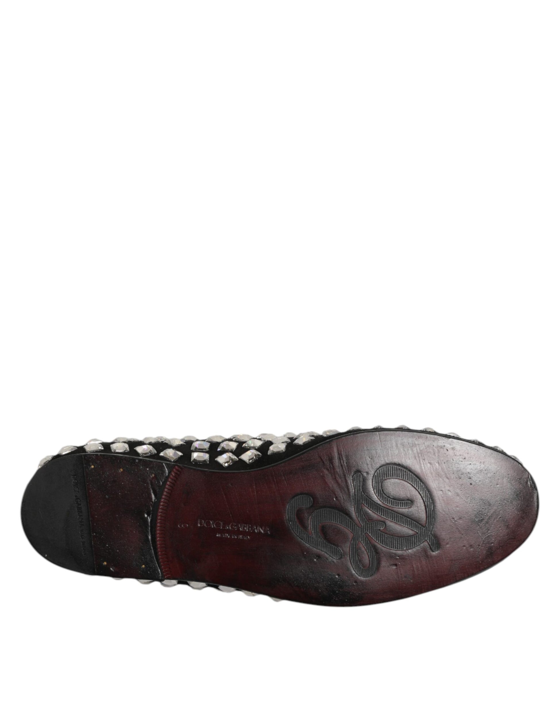A pair of black suede loafers with crystal embellishments, featuring a logo on the side