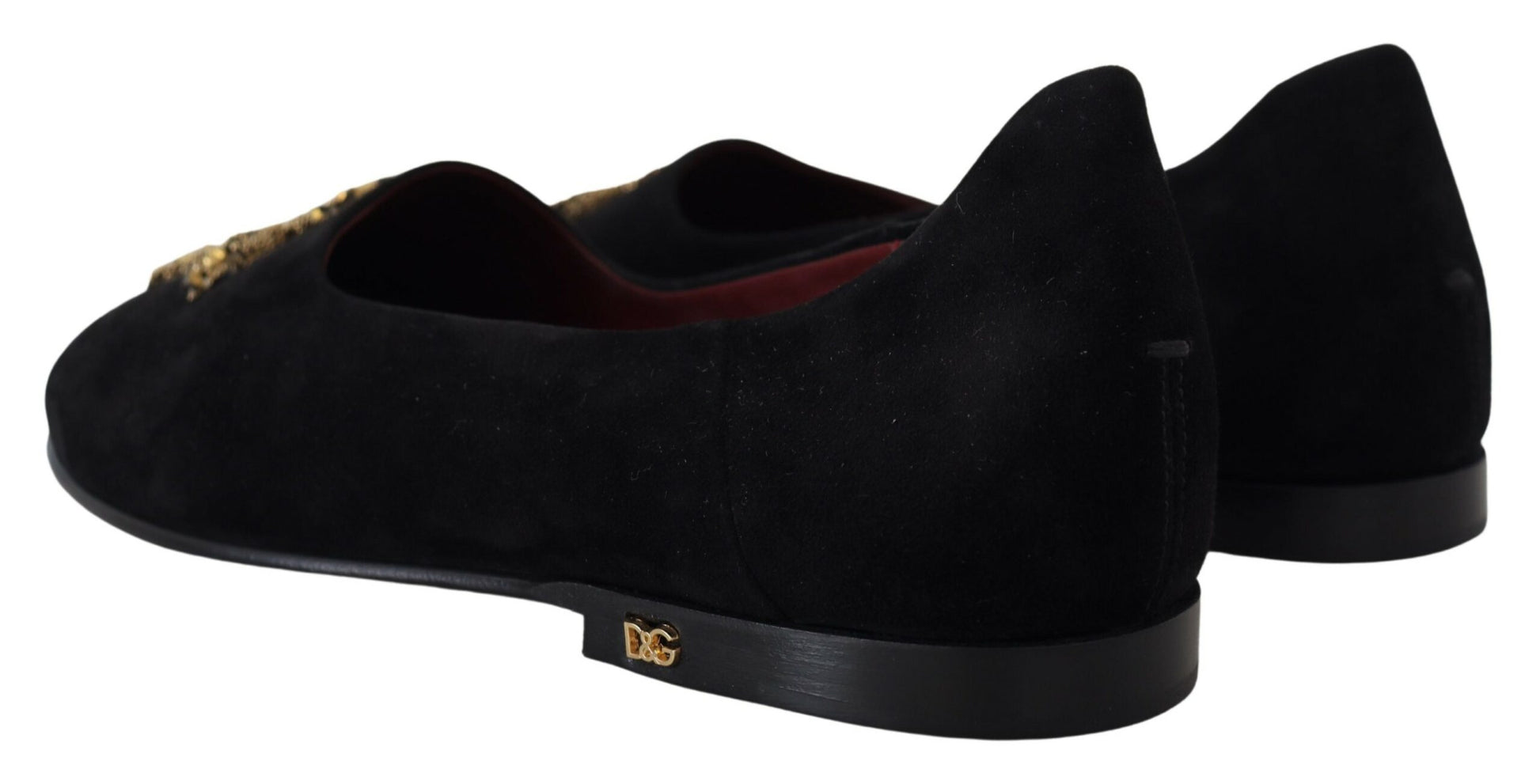 Pair of black velvet shoes with gold accents and a red sole