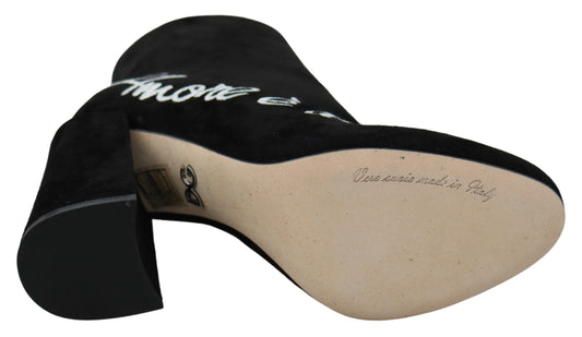 Black high heel shoe with a tan interior and white writing on the sole