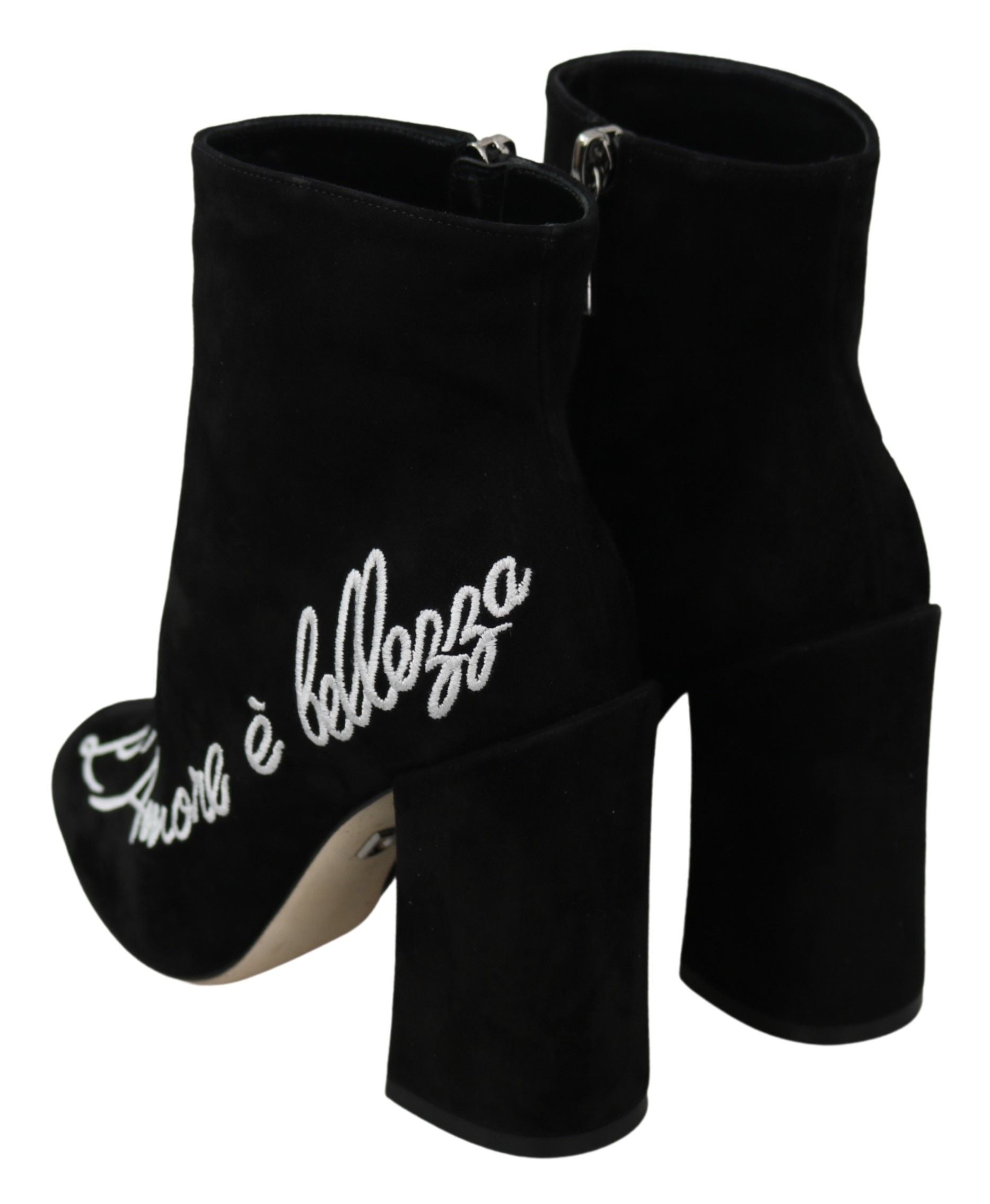 Pair of black suede boots with white embroidery on heels