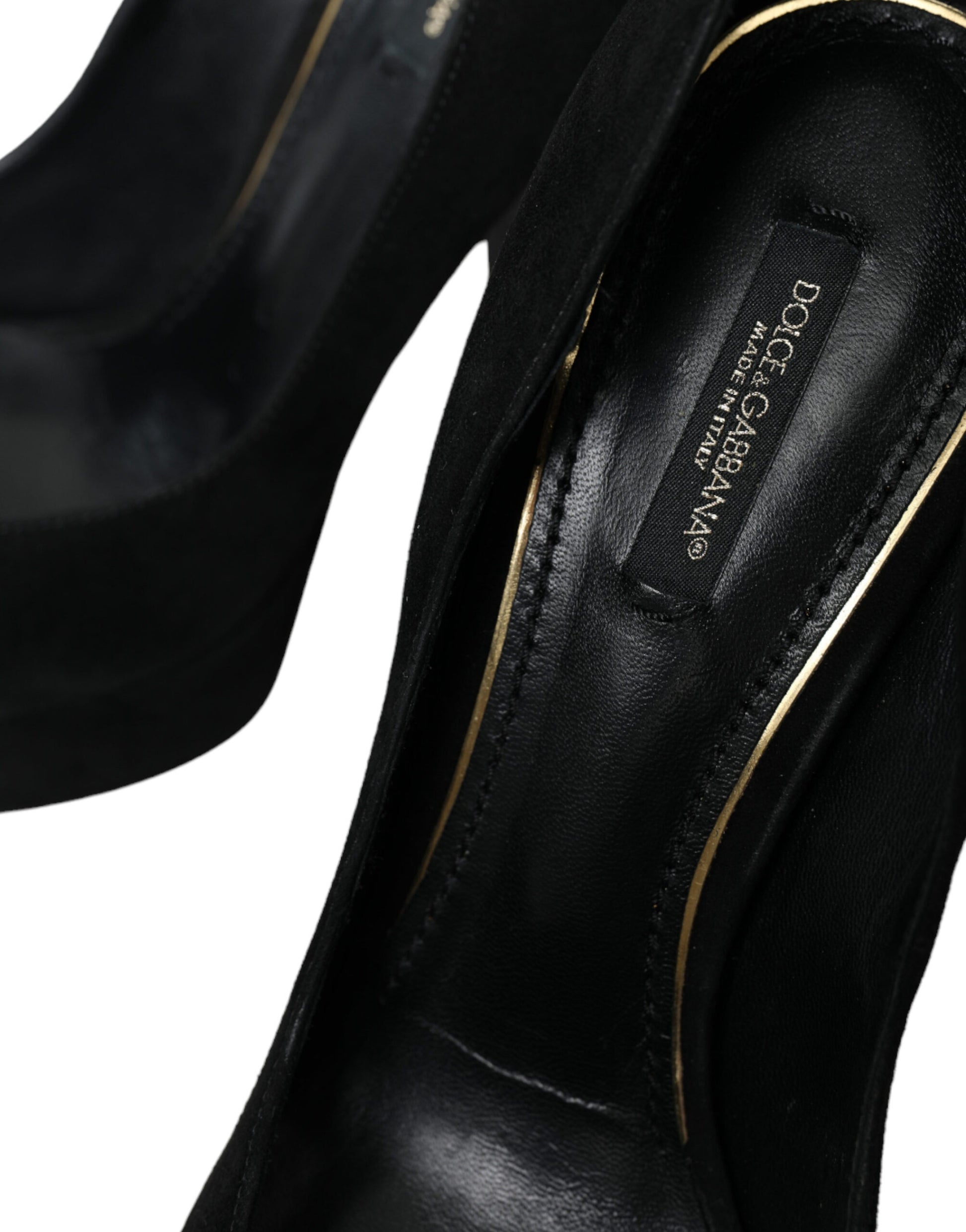 Black high heel shoe with gold accents and a label on the inside