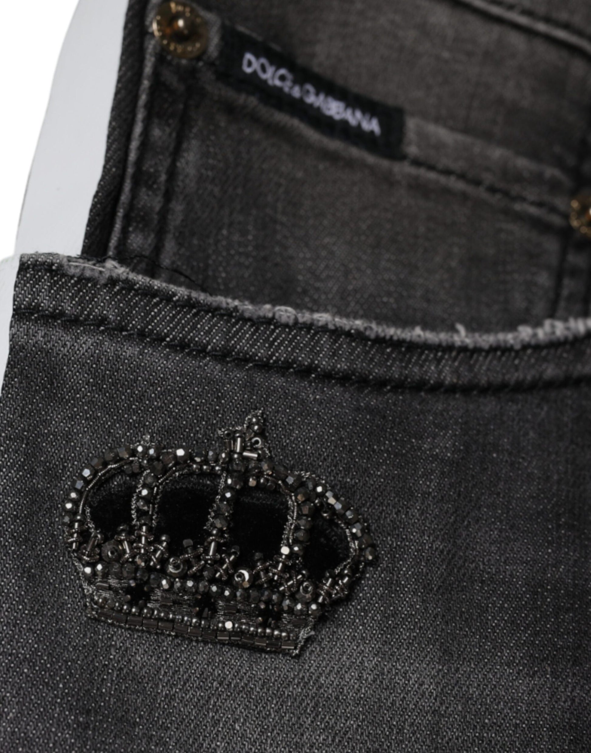 The jeans have a crown embroidered on them