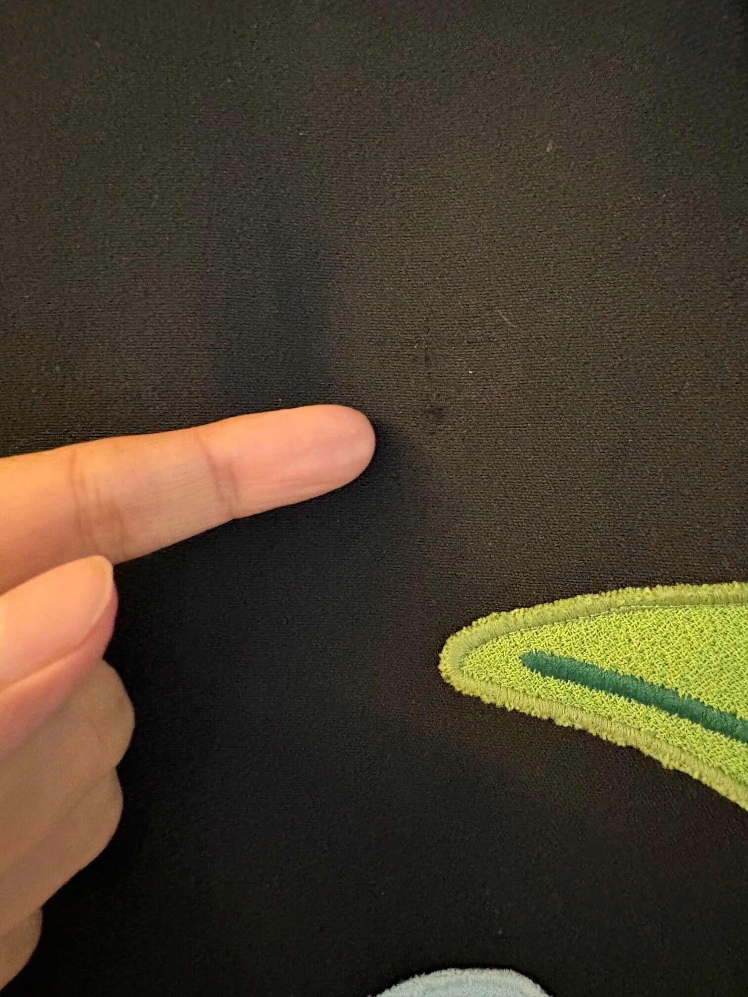A person's finger pointing at a black tiger jungle print sheath stretch dress