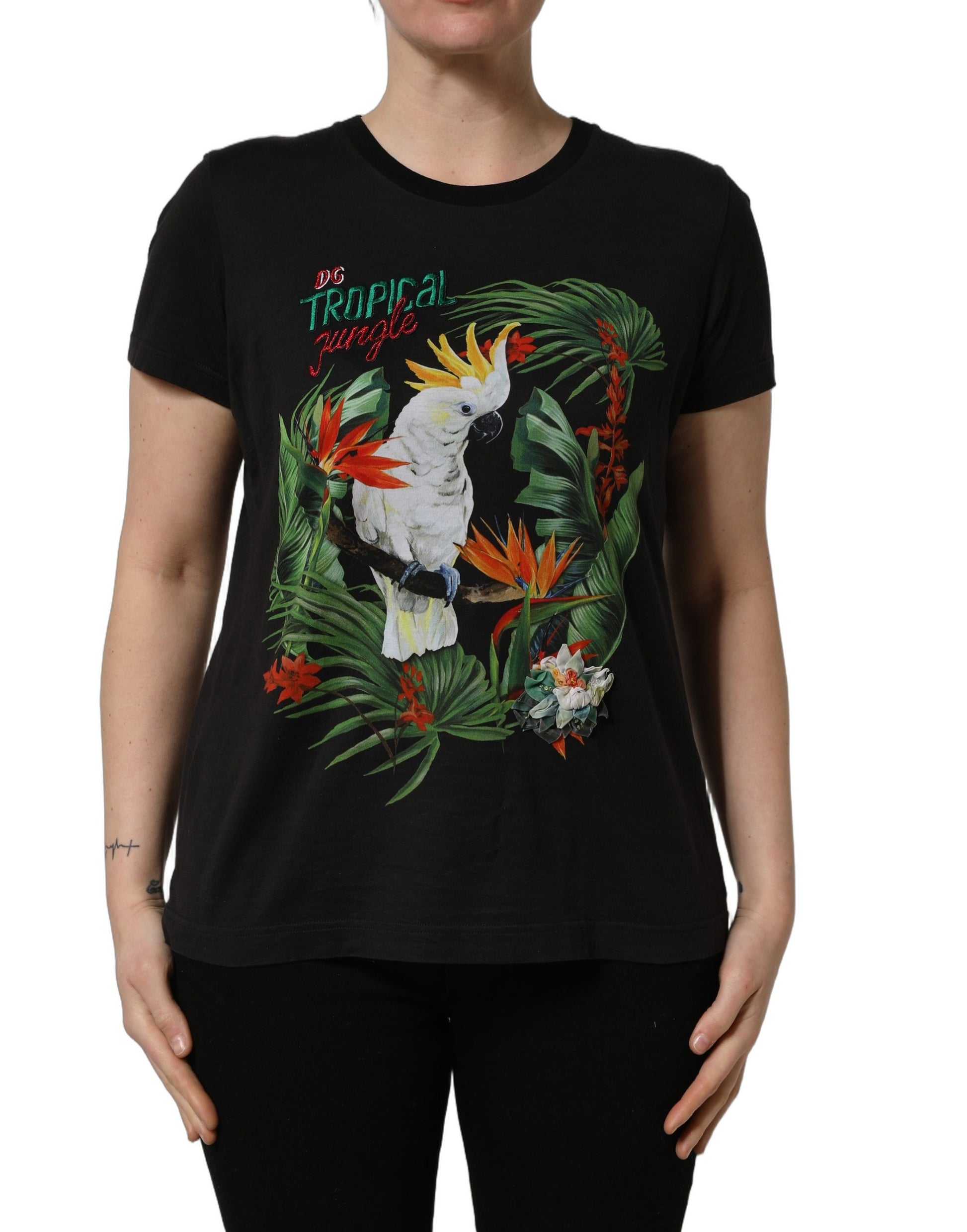 A black t-shirt with a tropical jungle print featuring birds and flowers