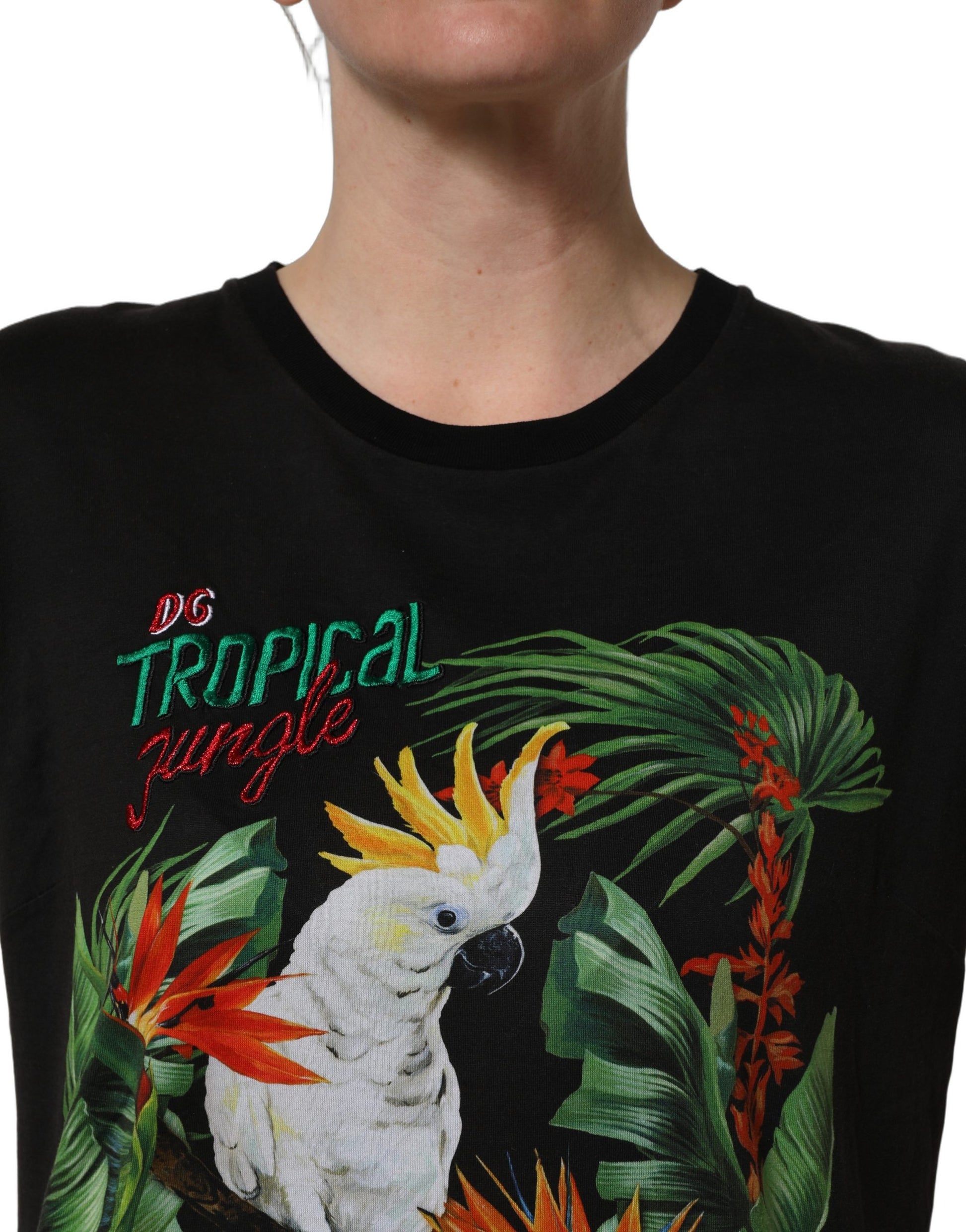 A black t-shirt with a tropical jungle print featuring a parrot and palm leaves