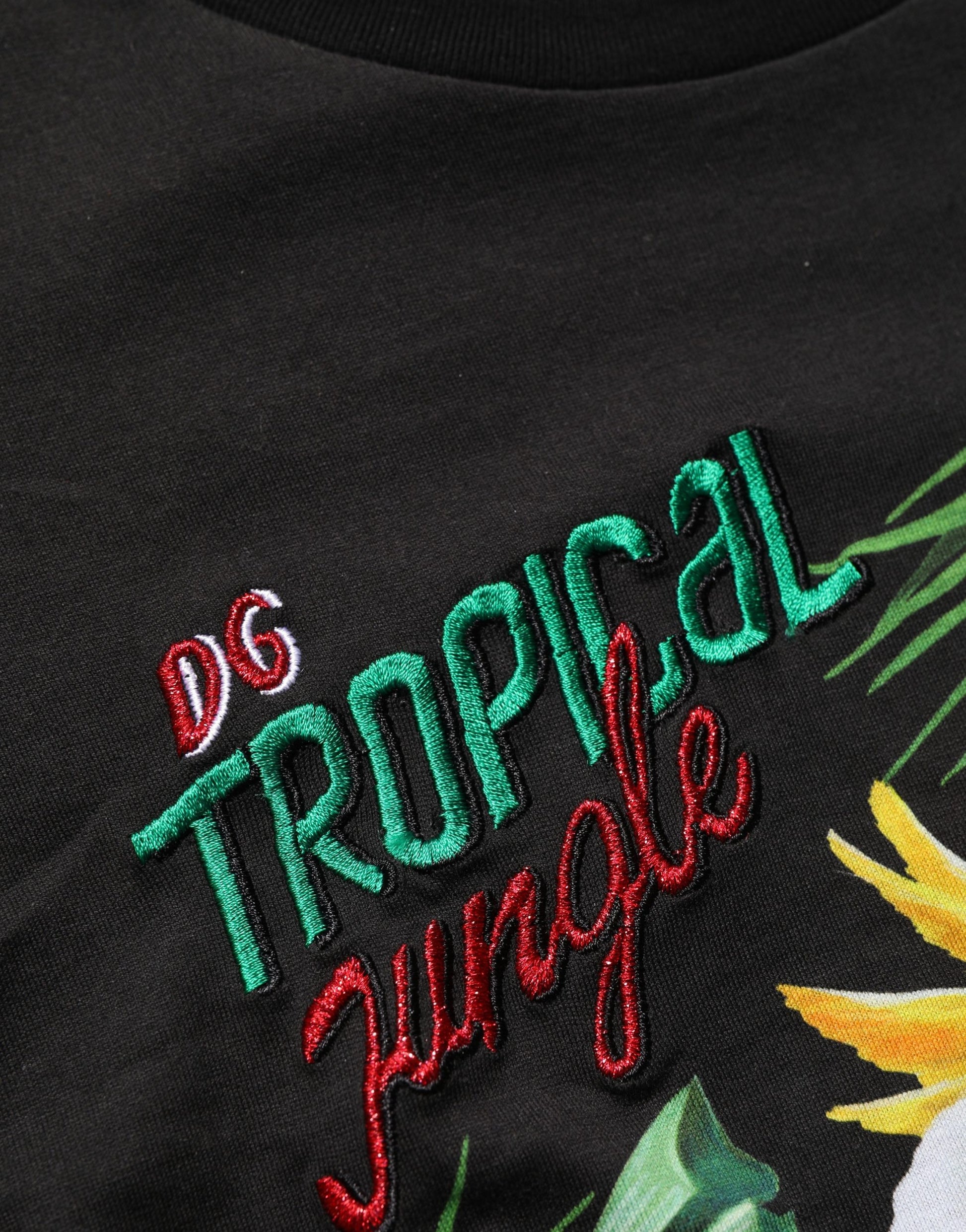 A black t-shirt with tropical jungle print and text embroidered on the front
