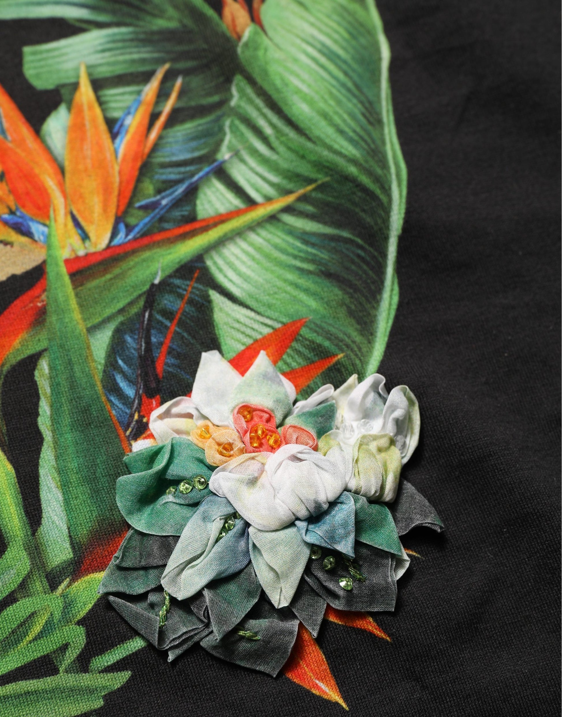 A tropical jungle print t-shirt with a round neckline and colorful floral embellishments