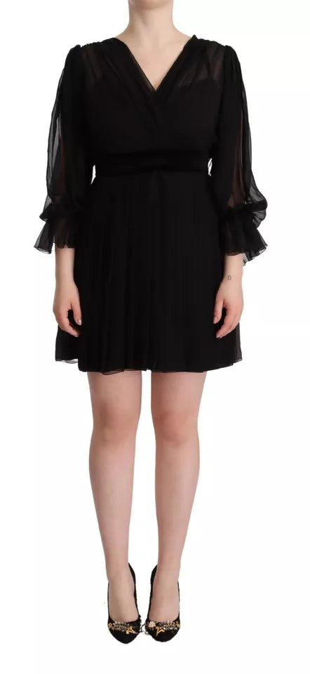 A black dress with long sleeves and a V-neck. It is an A-line style, which means it has a fitted waist that g
