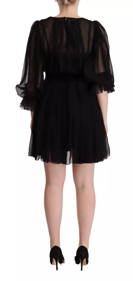 Black dress with long sleeves and v-neck, featuring lace detailing