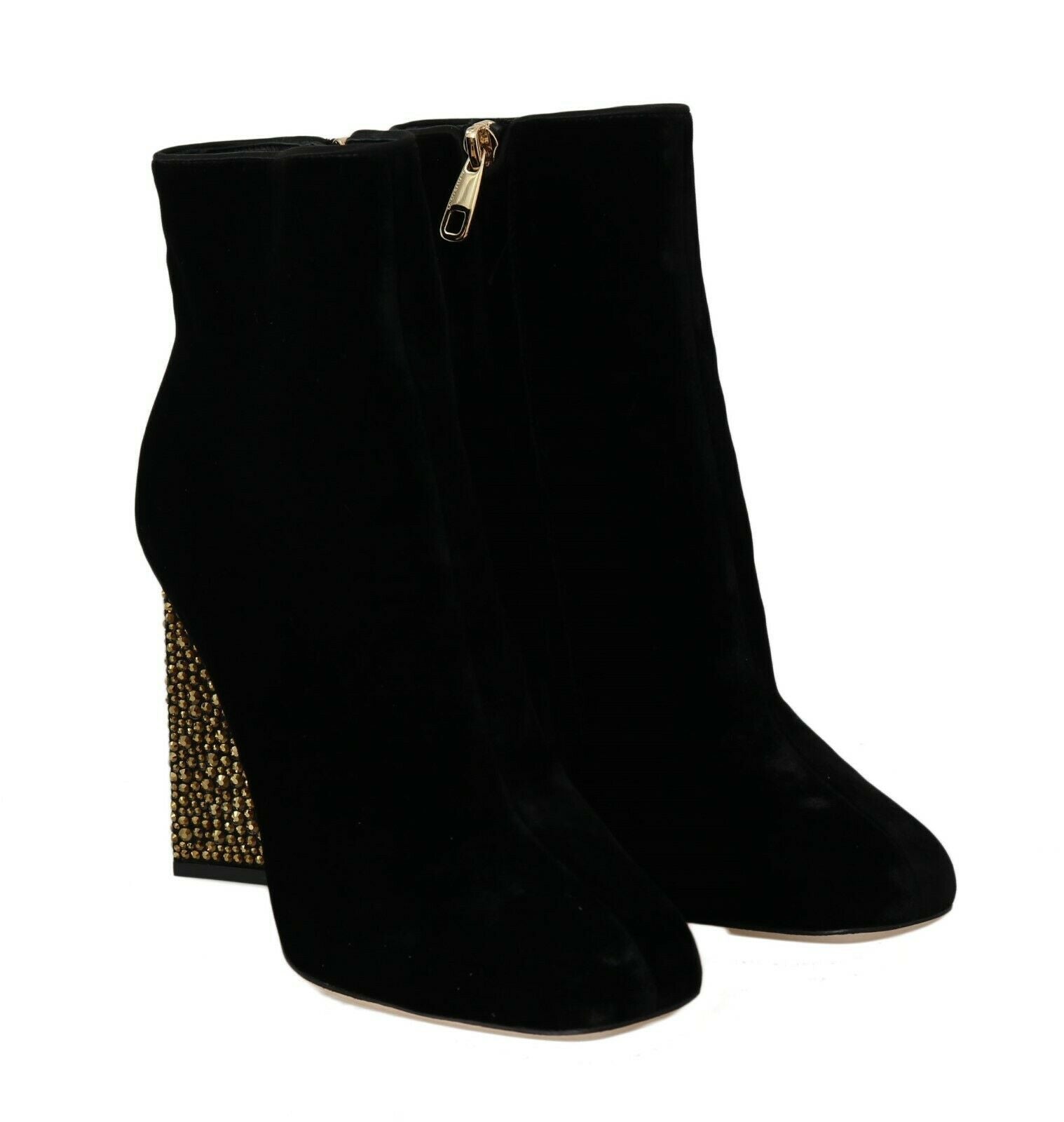 Pair of black suede knee high boots with gold zipper and embellishment on heel