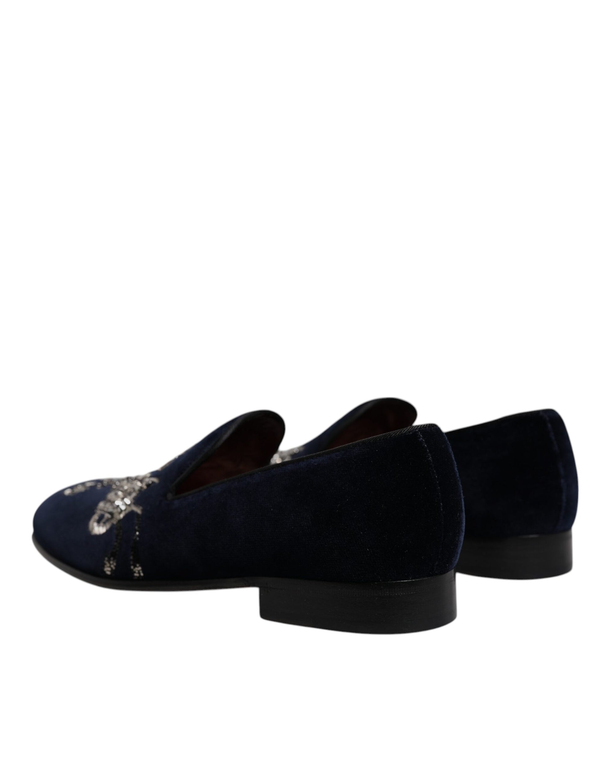 A pair of black velvet loafers with floral embroidery and a gunmetal heel