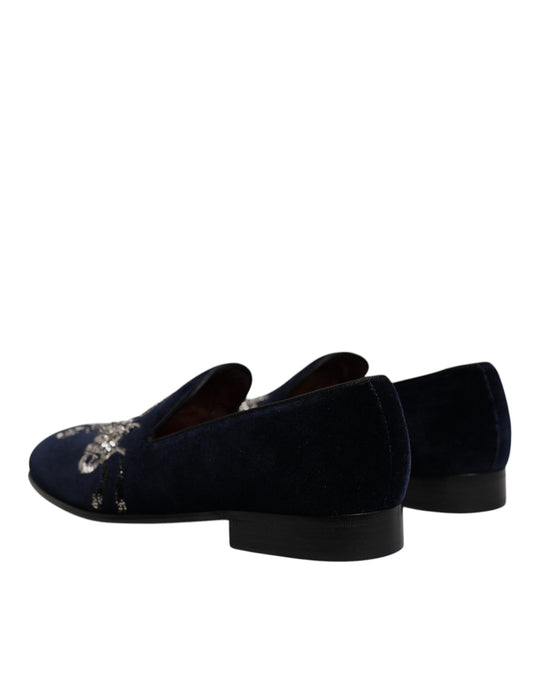 A pair of black velvet loafers with floral embroidery and a gunmetal heel