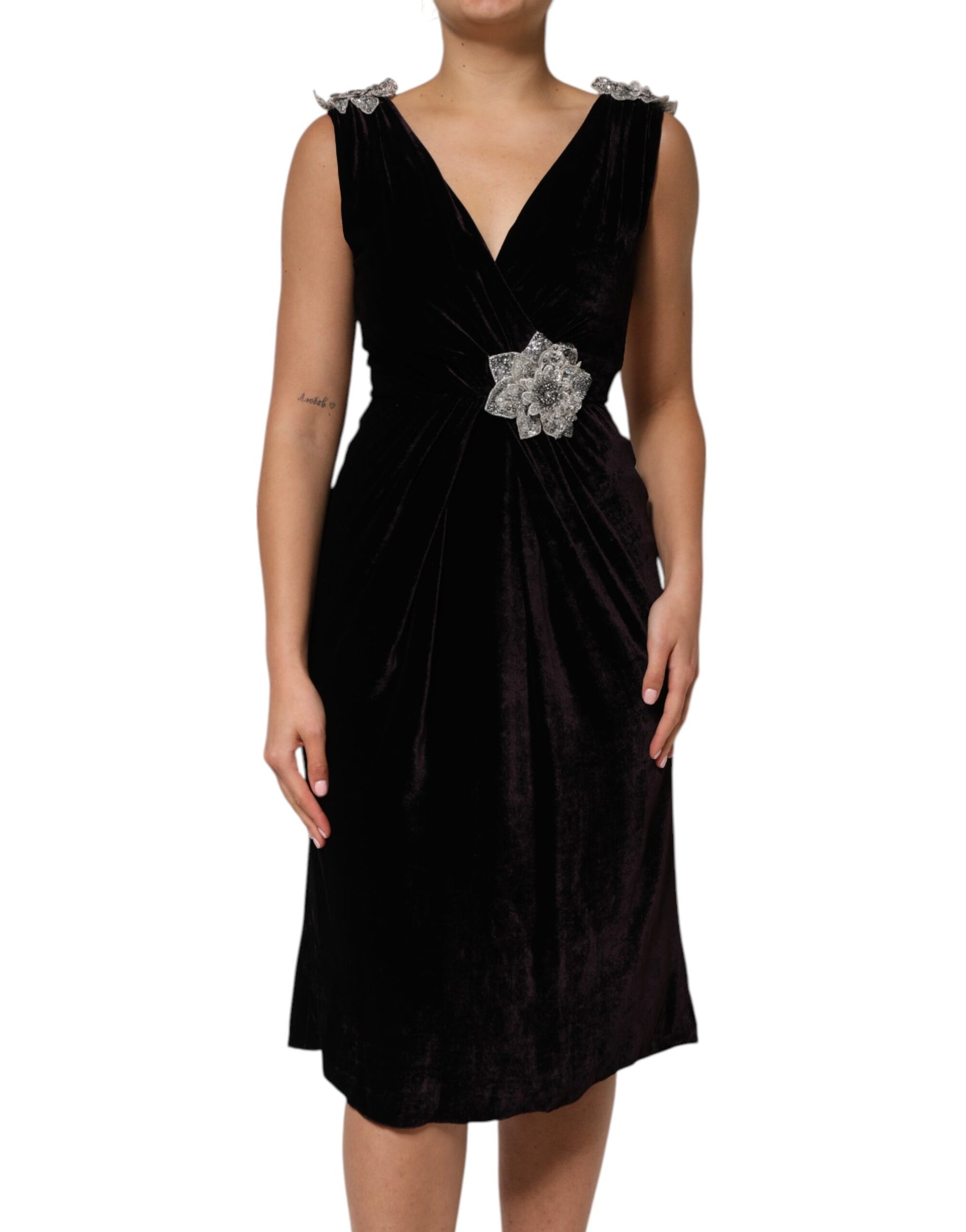 A black velvet dress with a flower embellishment on the waist, designed by Dolce & Gabbana