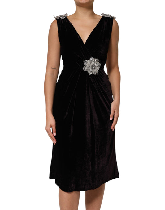 A black velvet dress with a flower embellishment on the waist, designed by Dolce & Gabbana