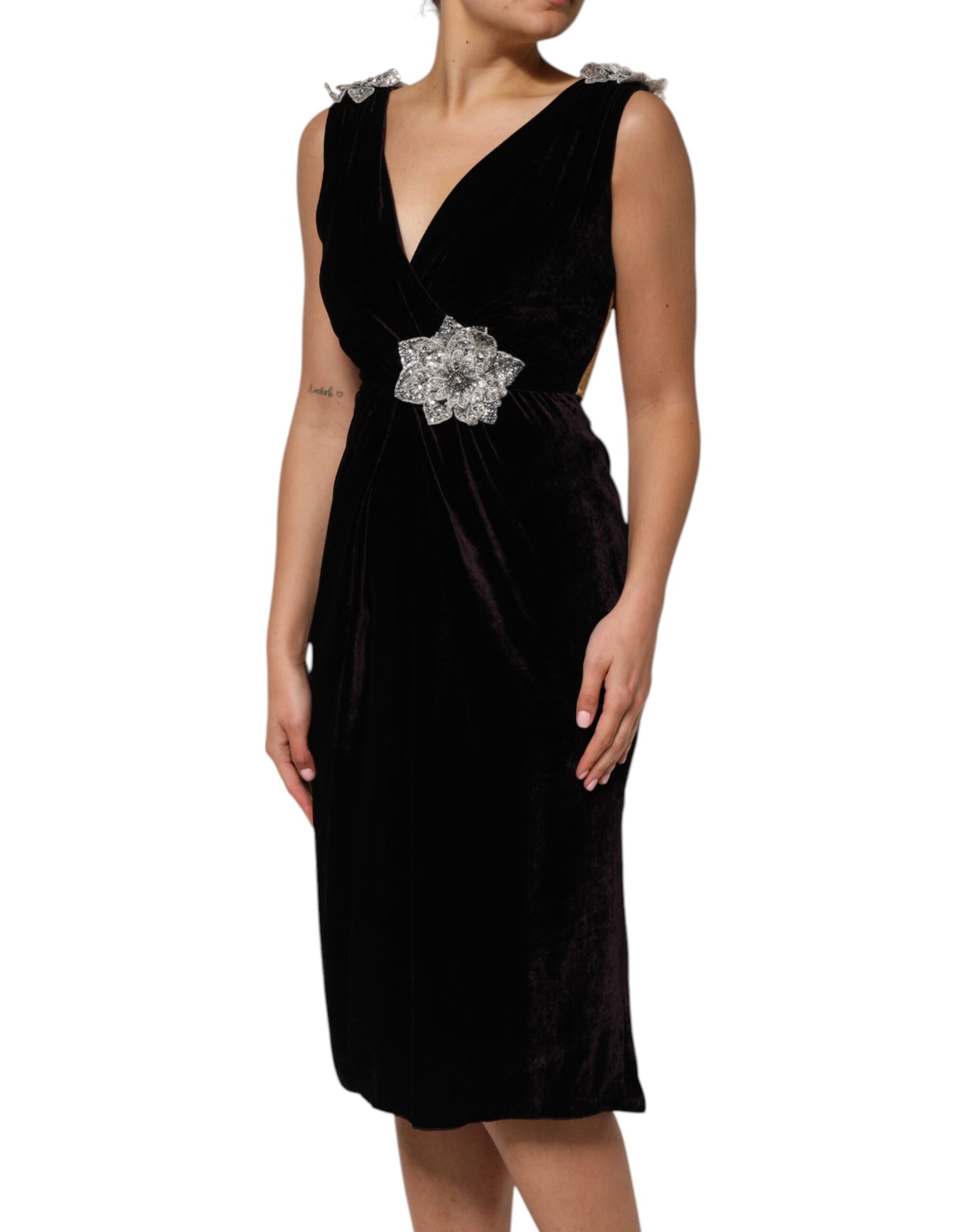 A black velvet dress with a flower embellishment on the waist and sleeves
