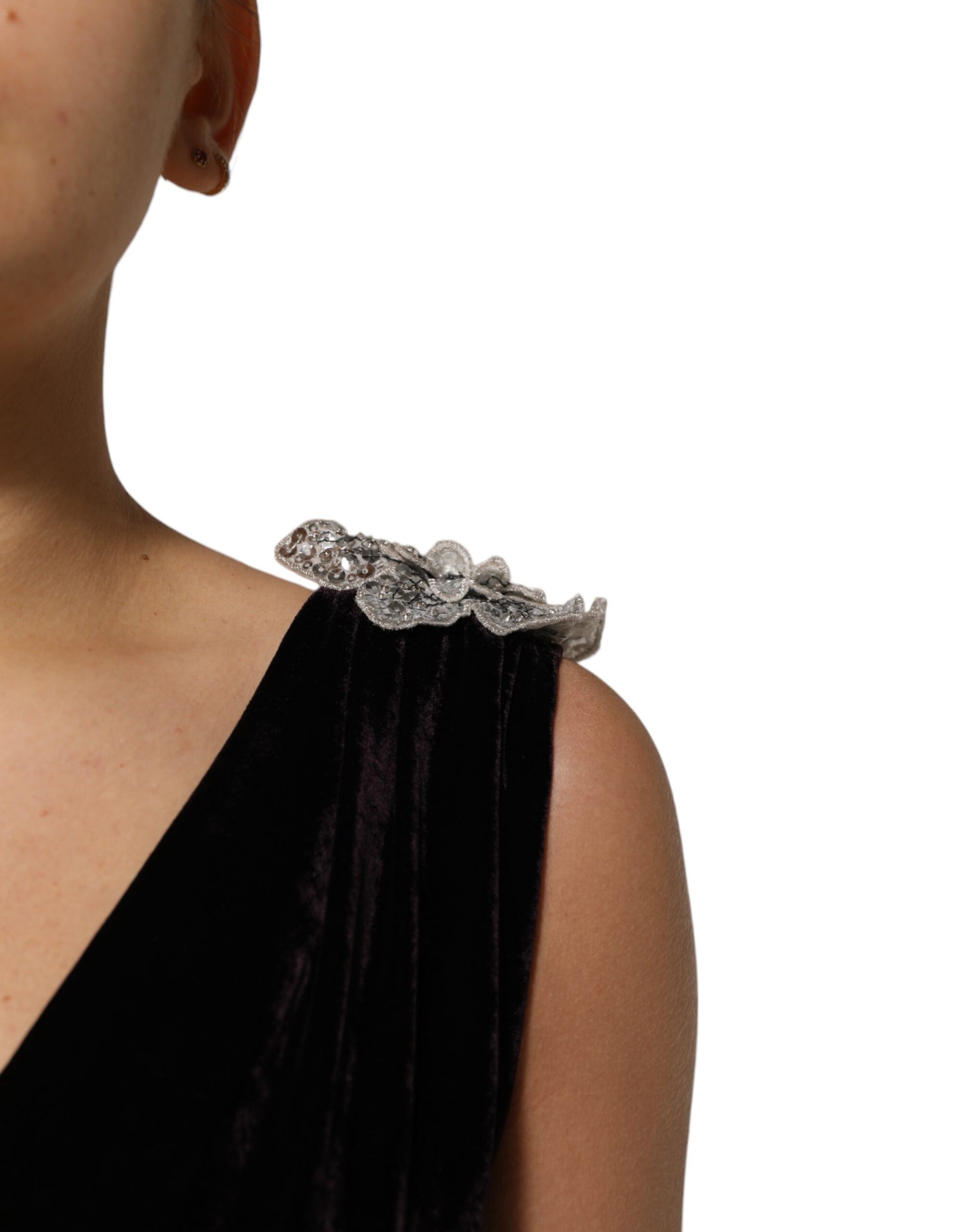 A black velvet dress with a flower embellishment on the shoulder
