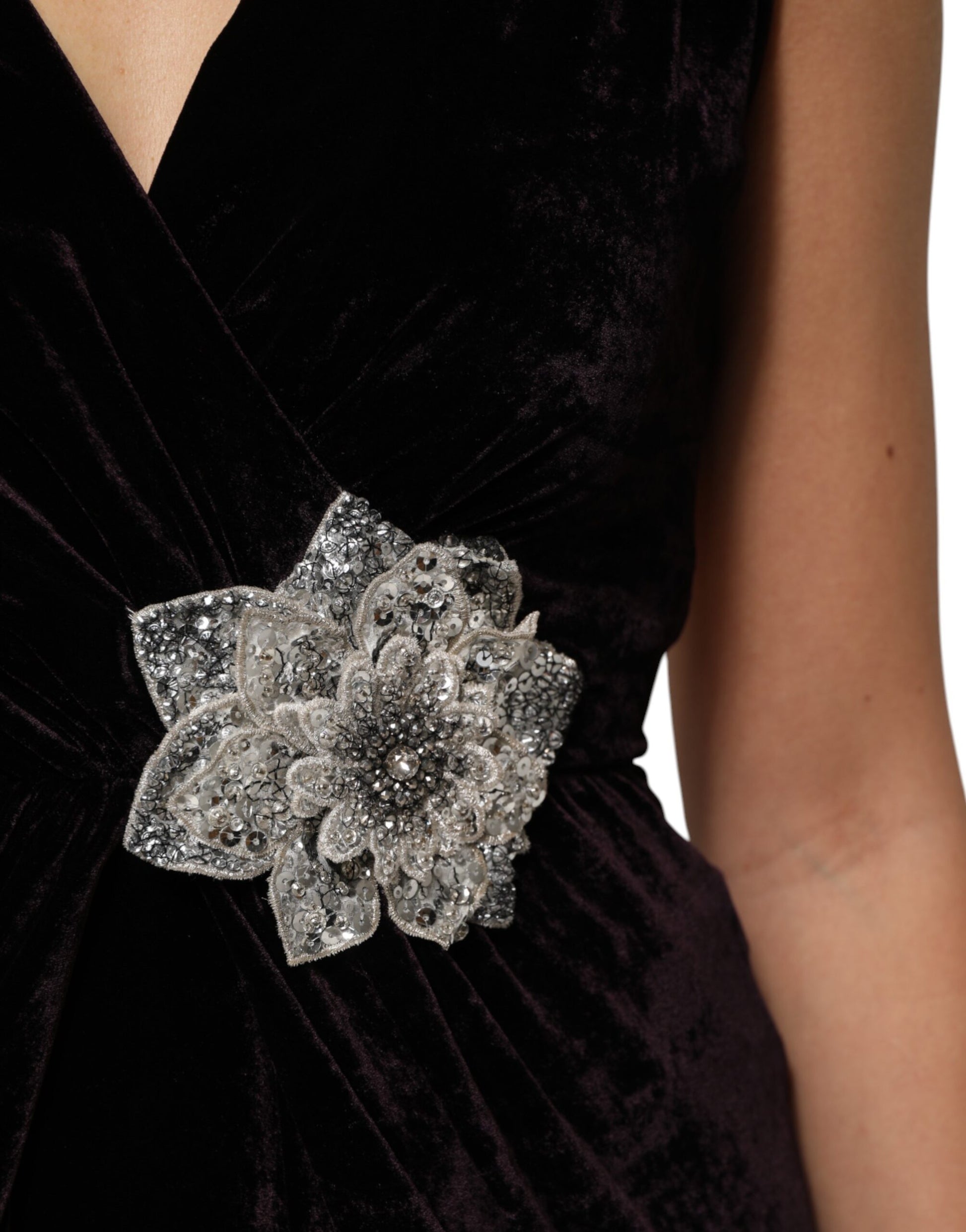A black velvet dress with a large flower embellishment on the bodice