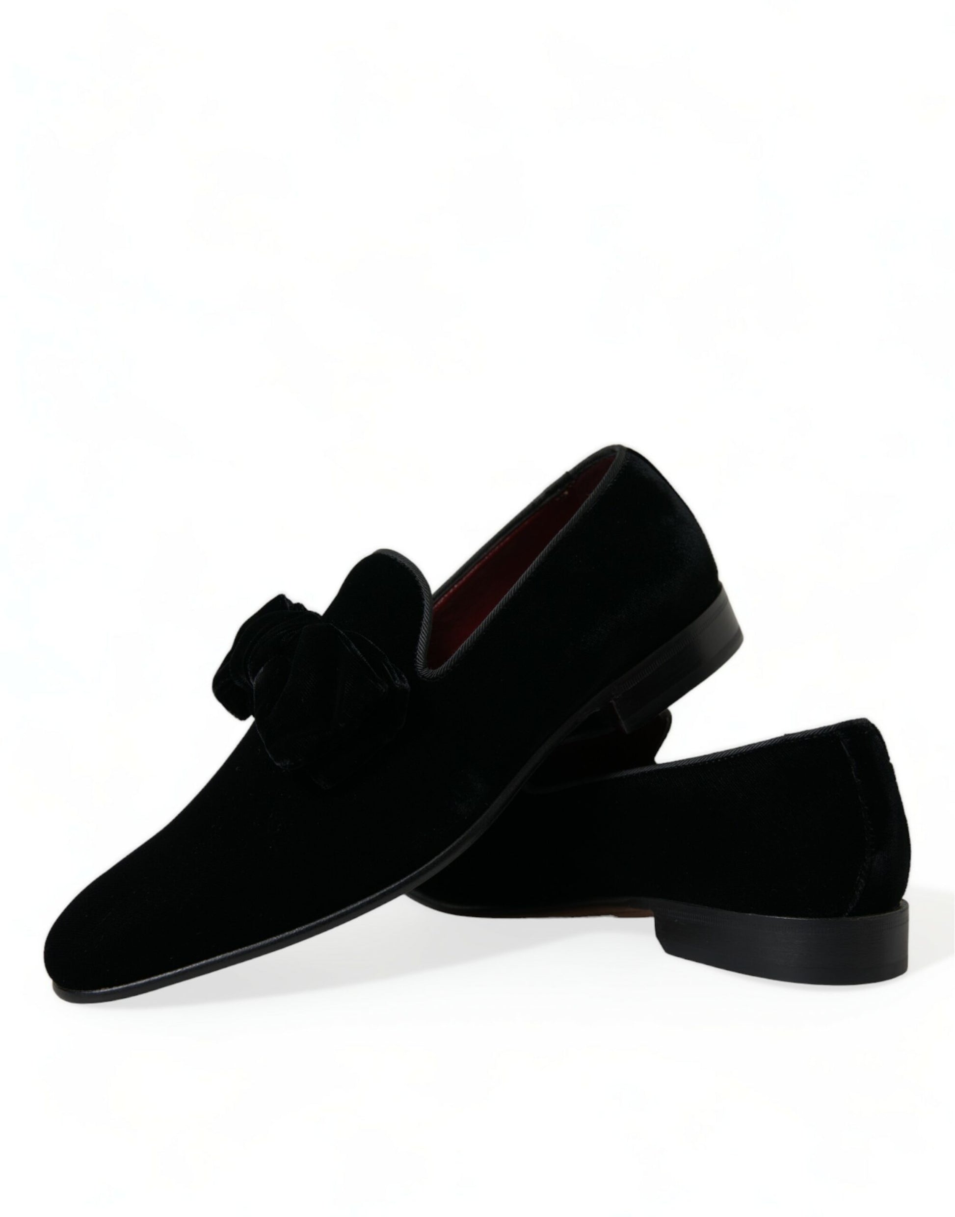 Pair of black velvet loafers with red trim and bow detailing