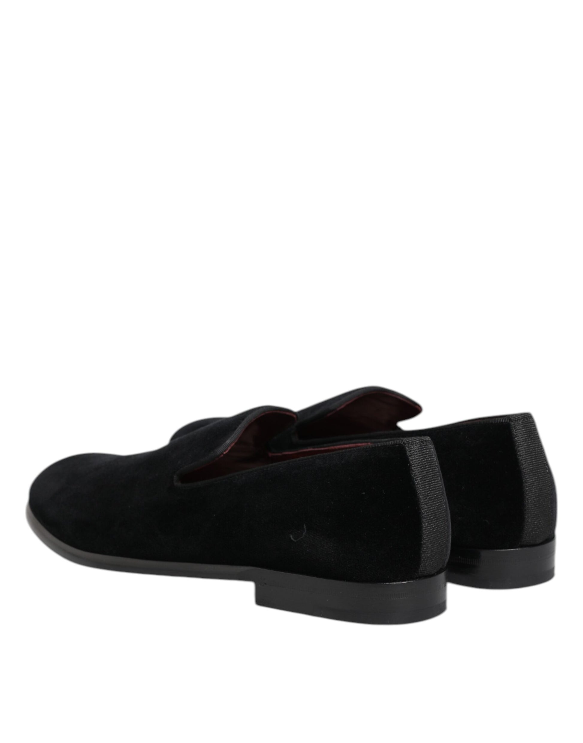 A pair of black velvet loafers with red accents, featuring a low heel and elastic panels for comfort