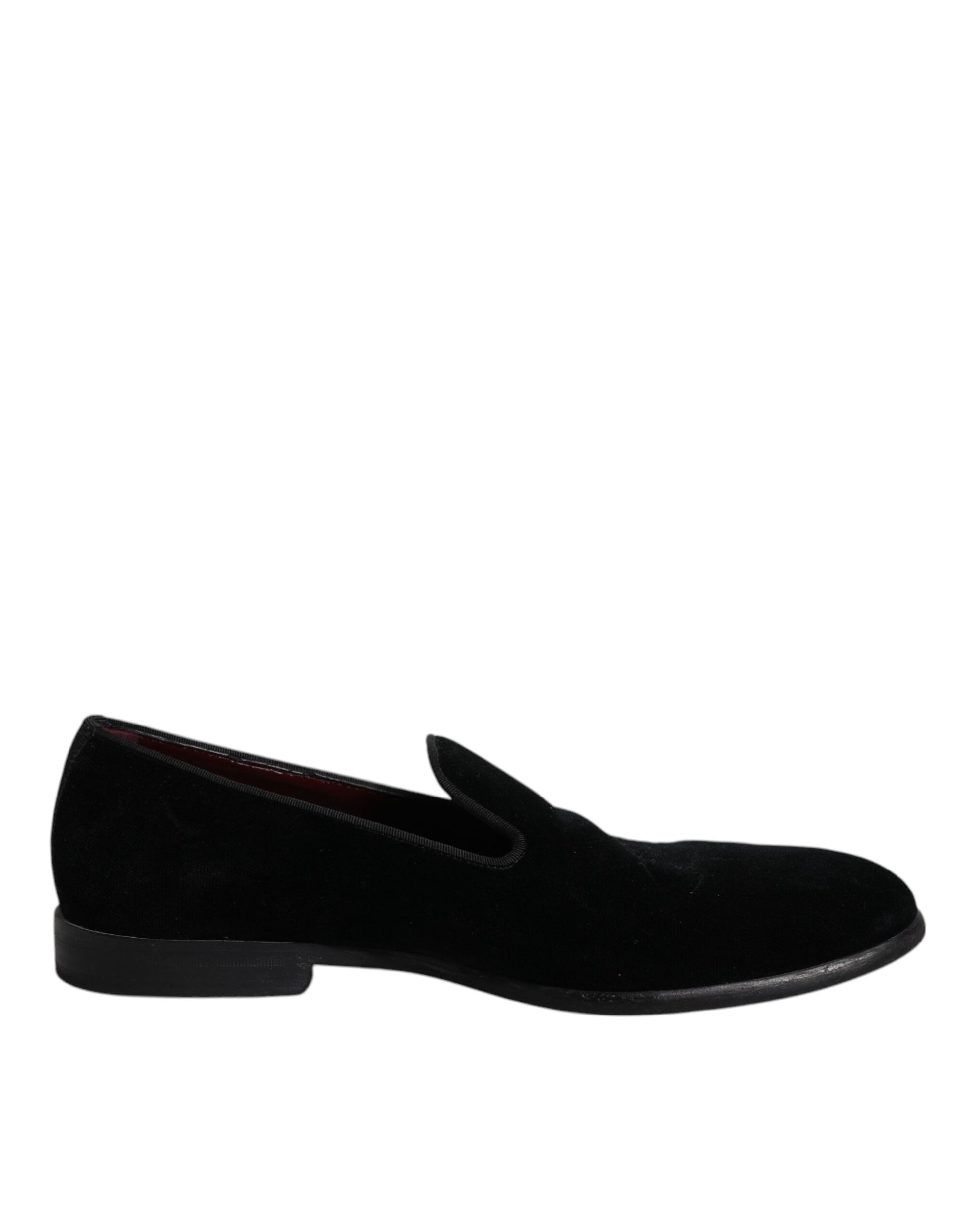 A pair of black velvet loafers with a red logo on the side, designed for formal men's dress shoes