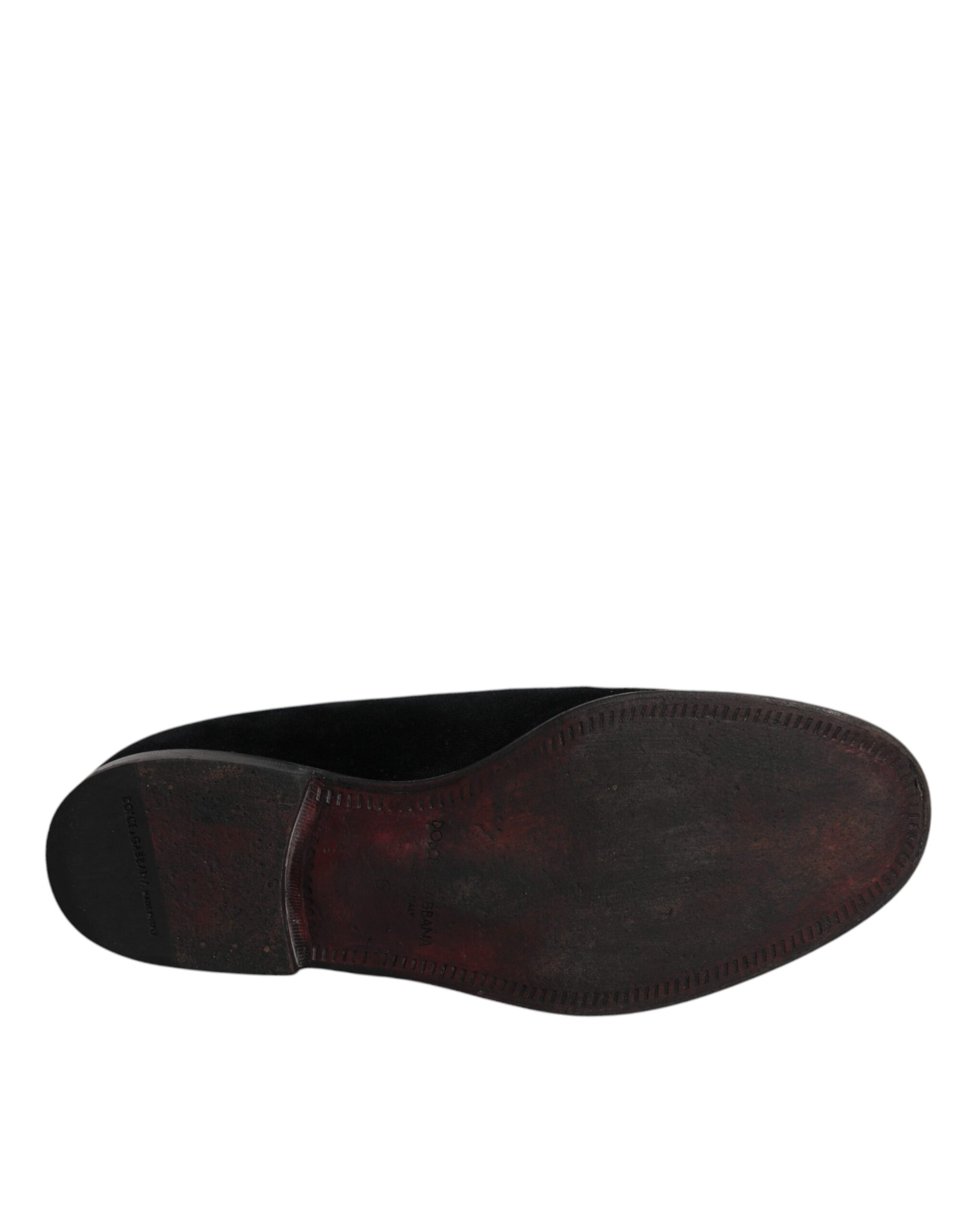 A pair of black velvet loafers with a shiny finish, featuring a round toe and elastic panels for comfort