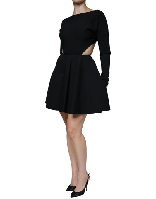 A black dress with cutouts on the sides and sleeves. It is made of viscose material and has long sleeves. The