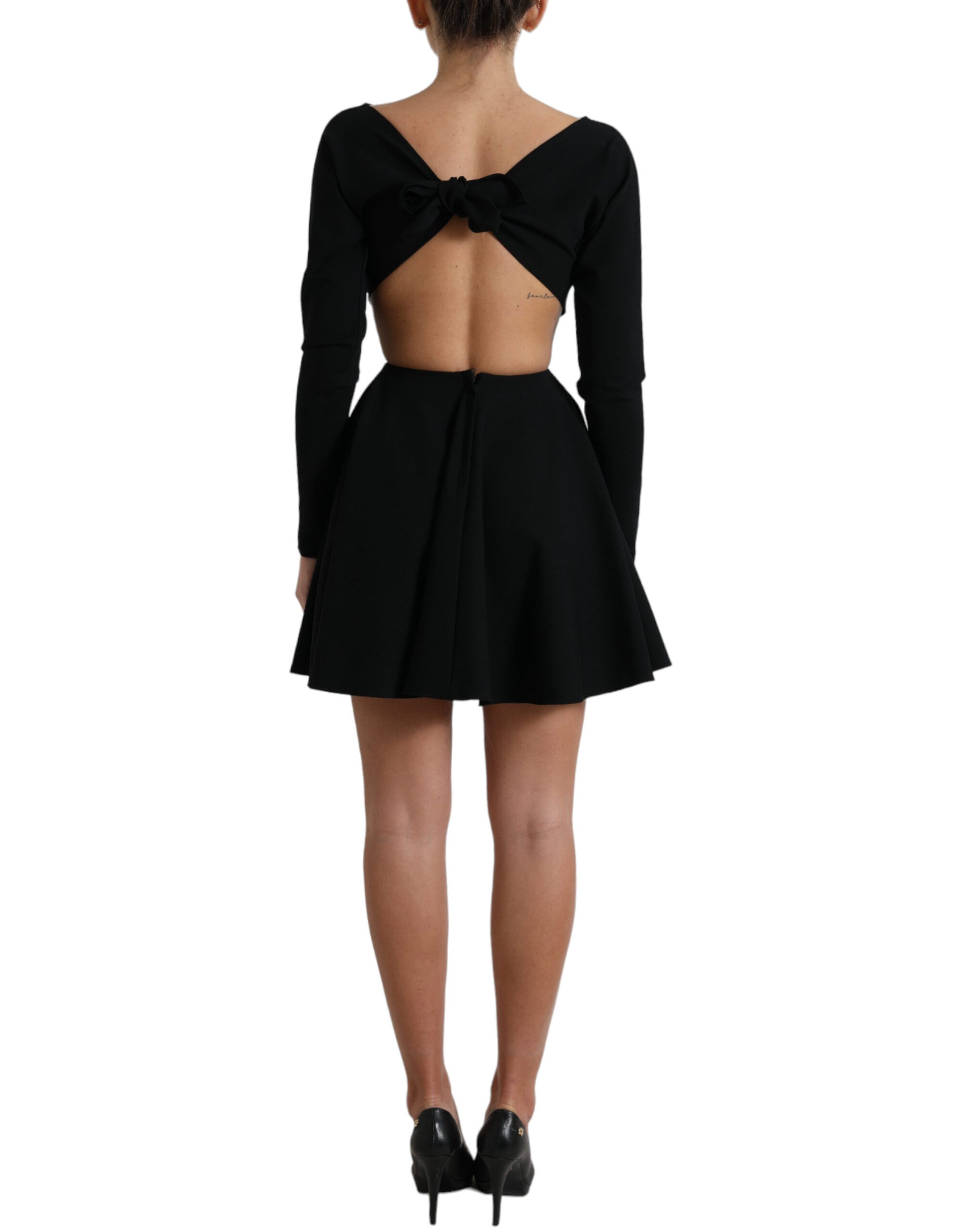 A black dress with cutouts on the back and sides. It features long sleeves and is made of viscose material
