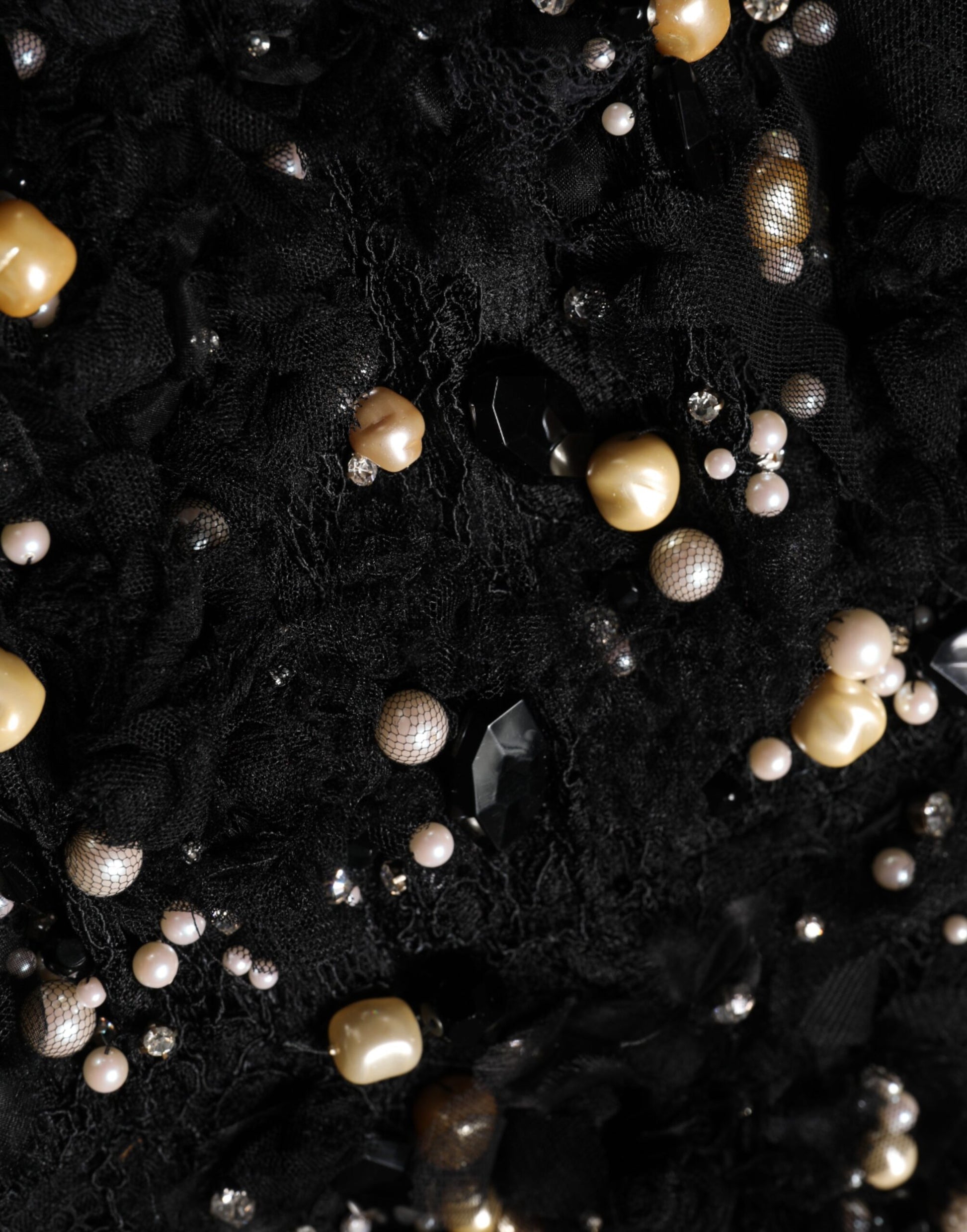 A black dress with pearl embellishments and a viscose fabric