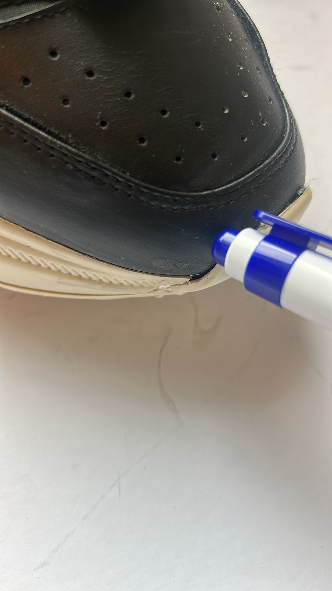 Black shoe with blue pen in its sole