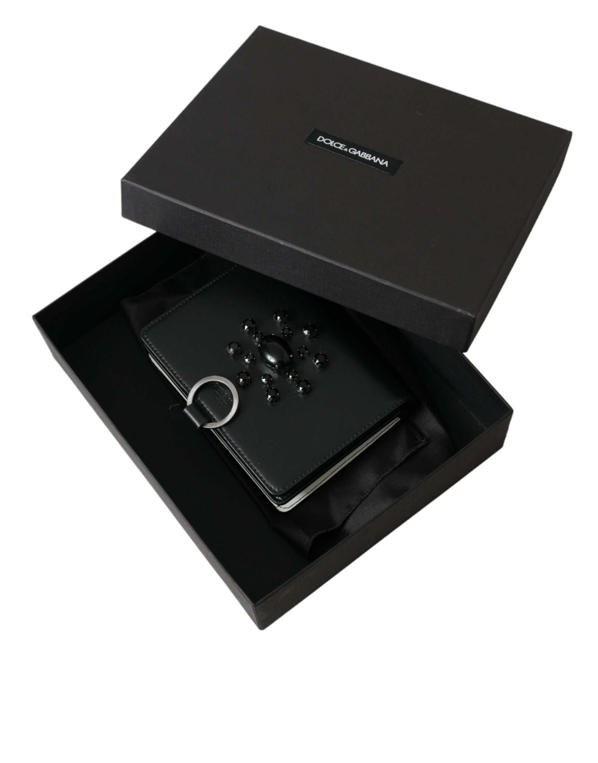 Black box containing a black video game controller and a black case with a ring on top