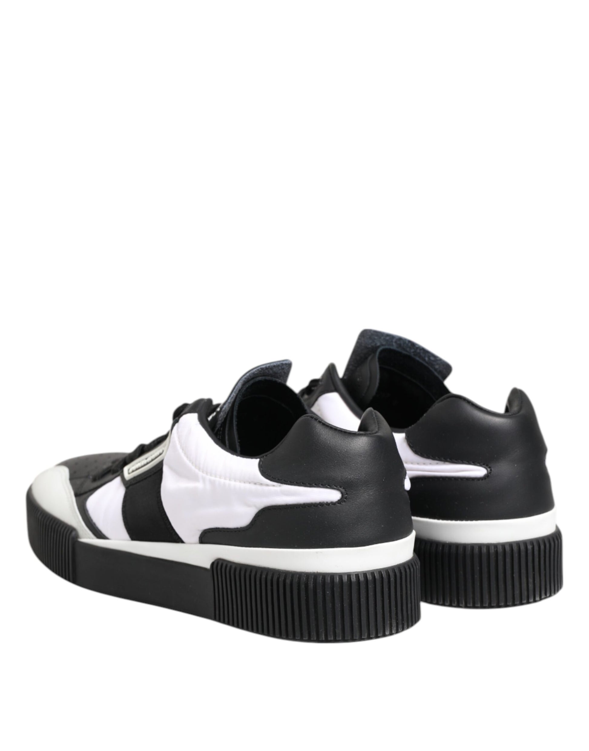 Pair of black and white leather sneakers with laces, featuring a low top design