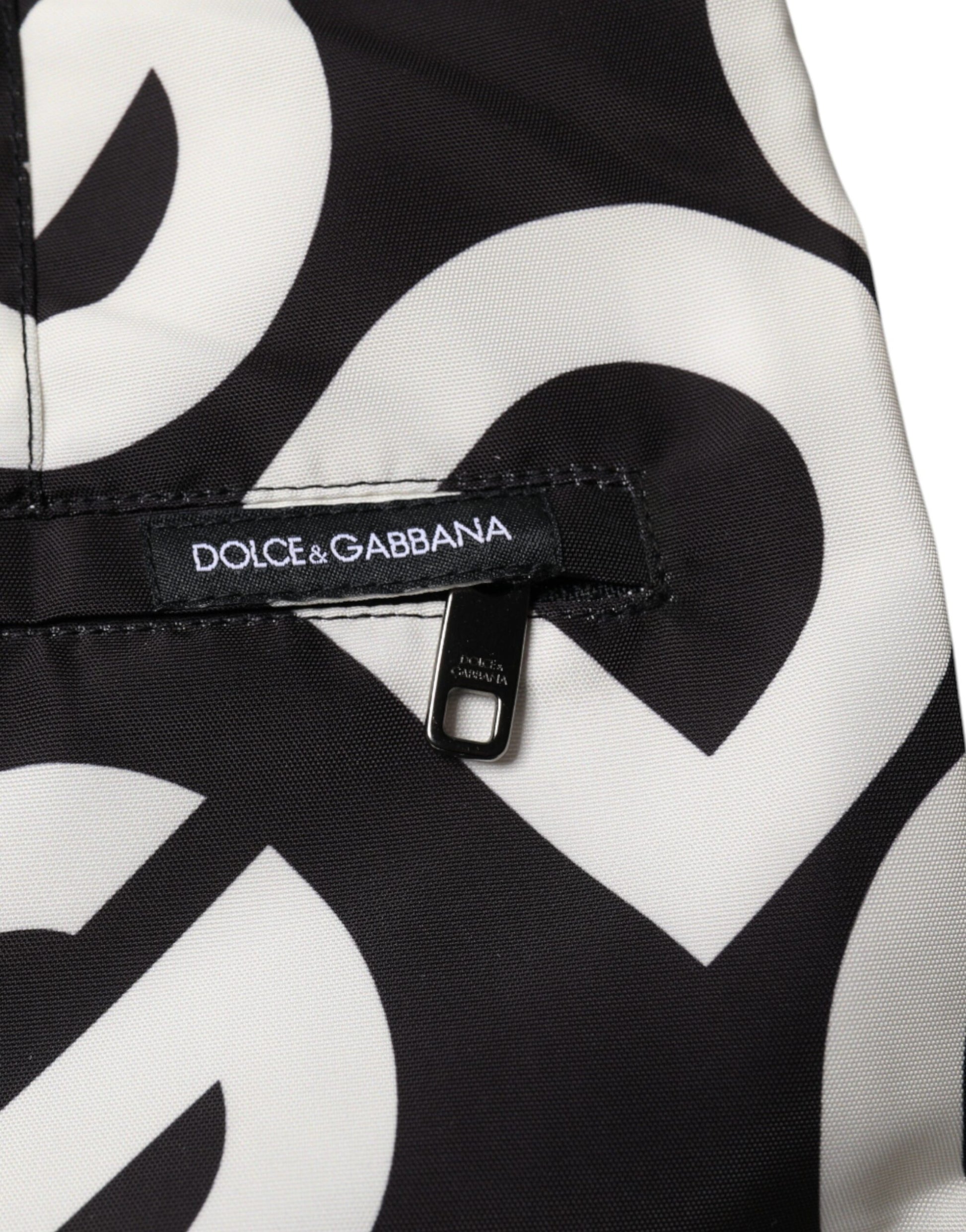A pair of black and white beach shorts with a logo on the waistband