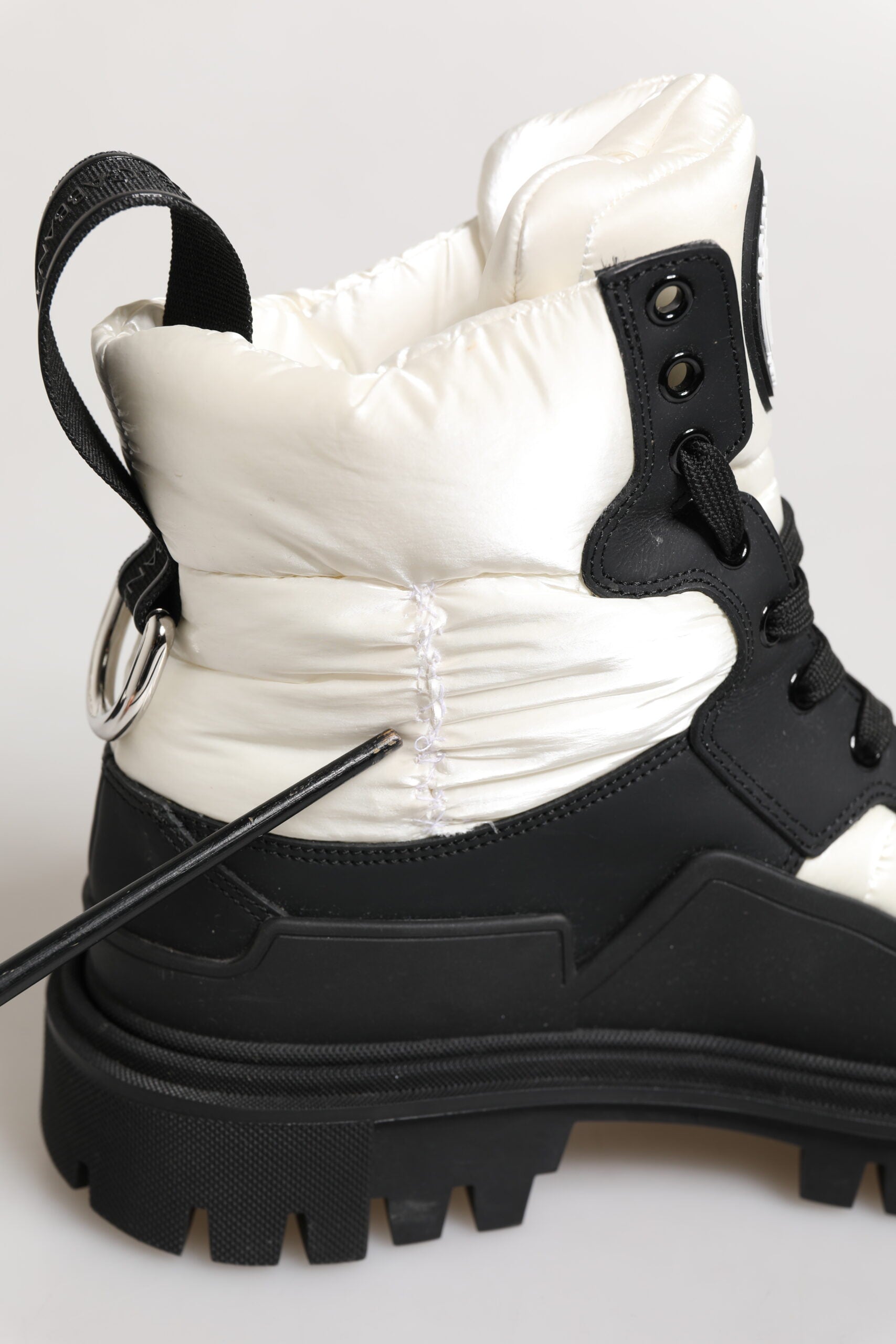 Black and white boot with laces and a zipper closure