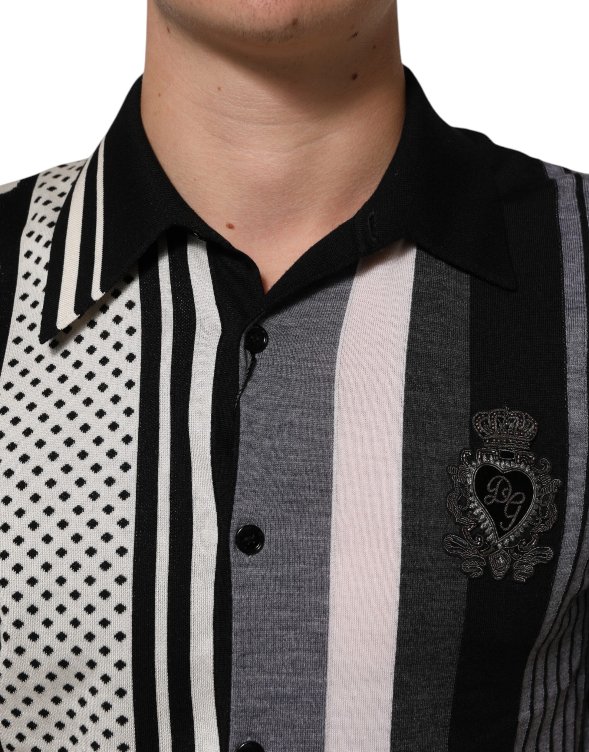 Man wearing striped shirt with heart emblem on left chest