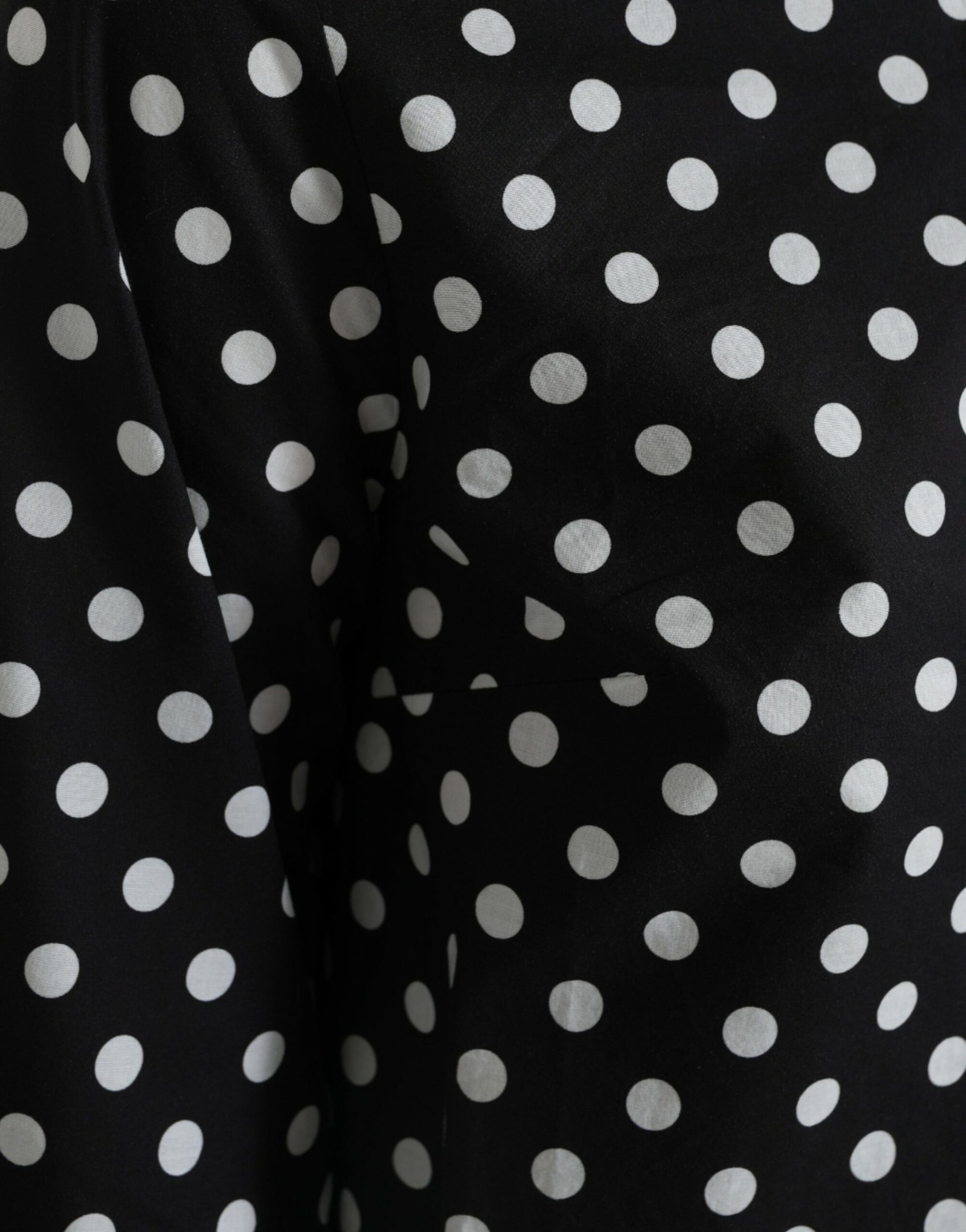 A black dress with white polka dots, featuring a nylon material and a shift style