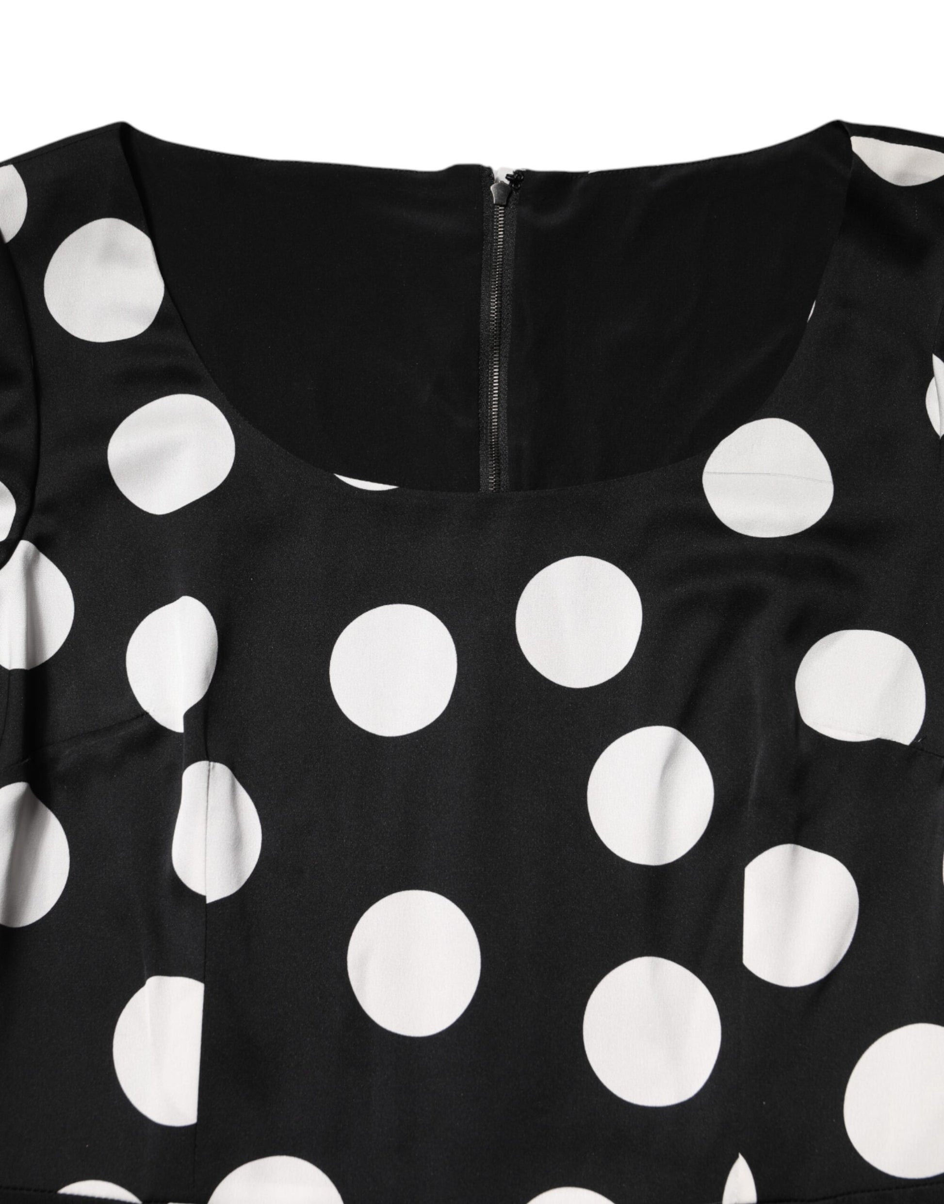A black midi dress with white polka dots, featuring a sheath silhouette