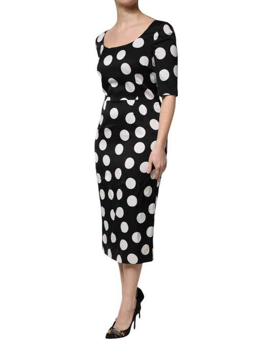 A black midi dress with white polka dots, made of silk