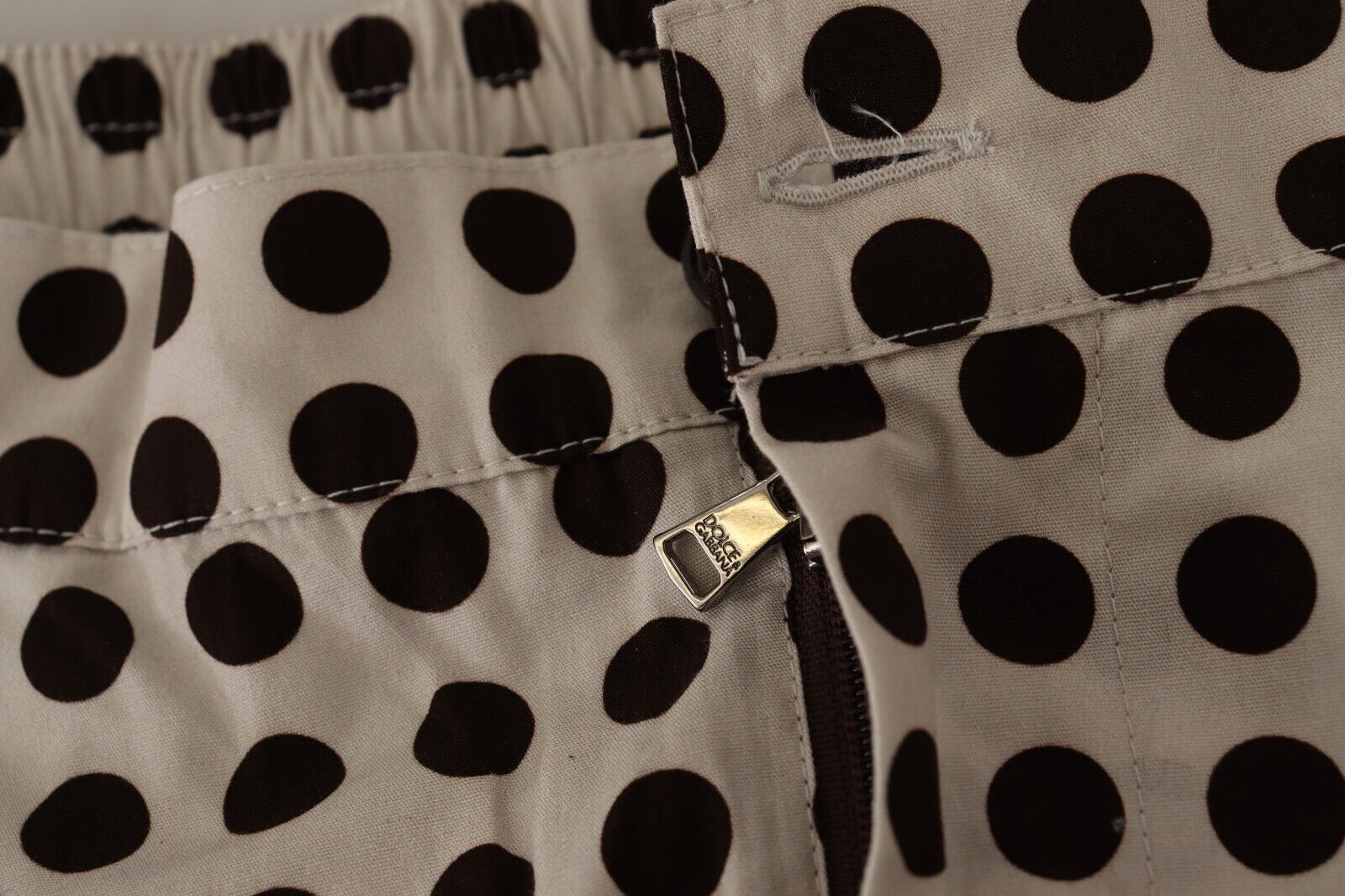 Pair of women's pants with black polka dots on a beige background