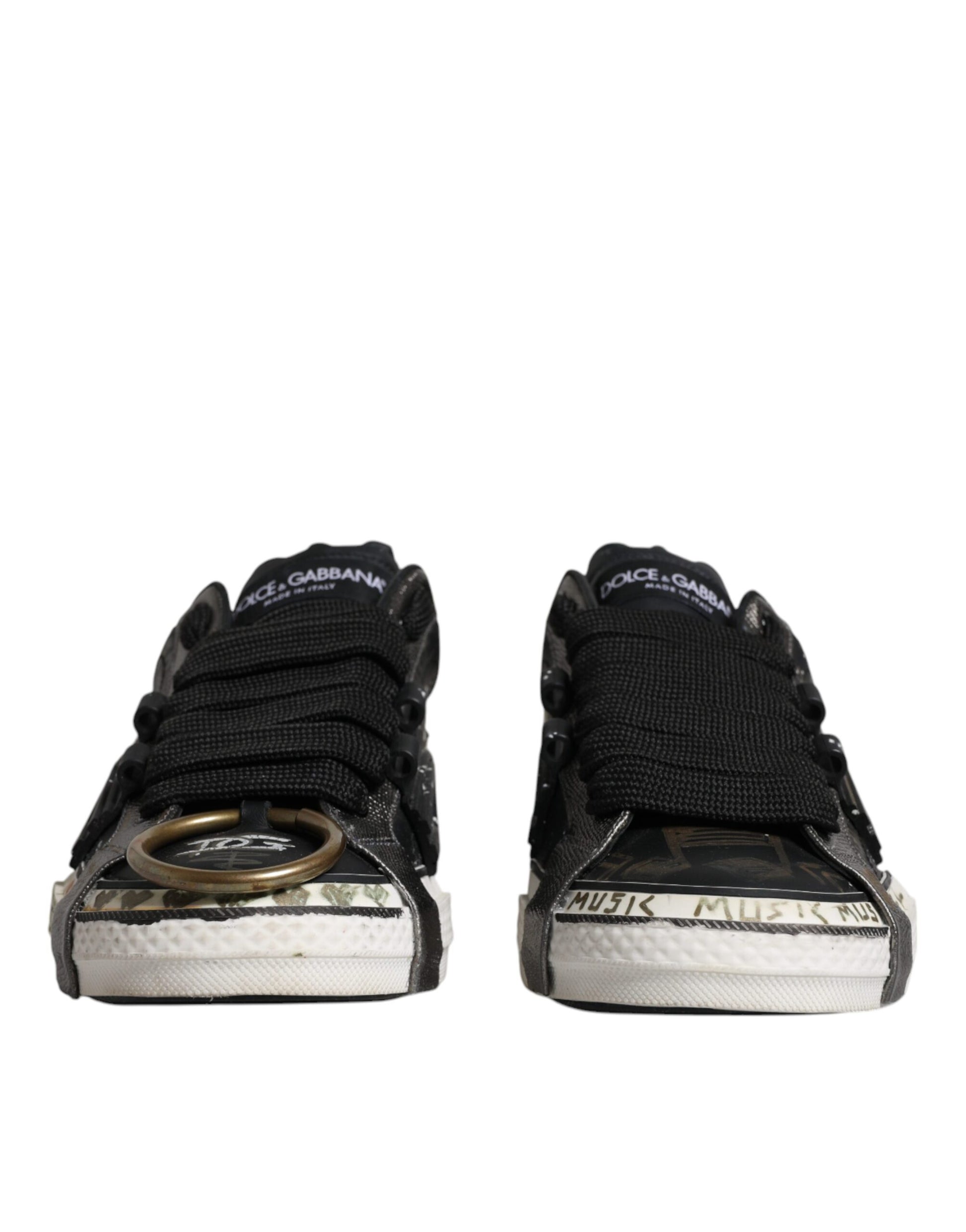 Pair of black and white sneakers with brand name on side, featuring laces and a small ring on the toe