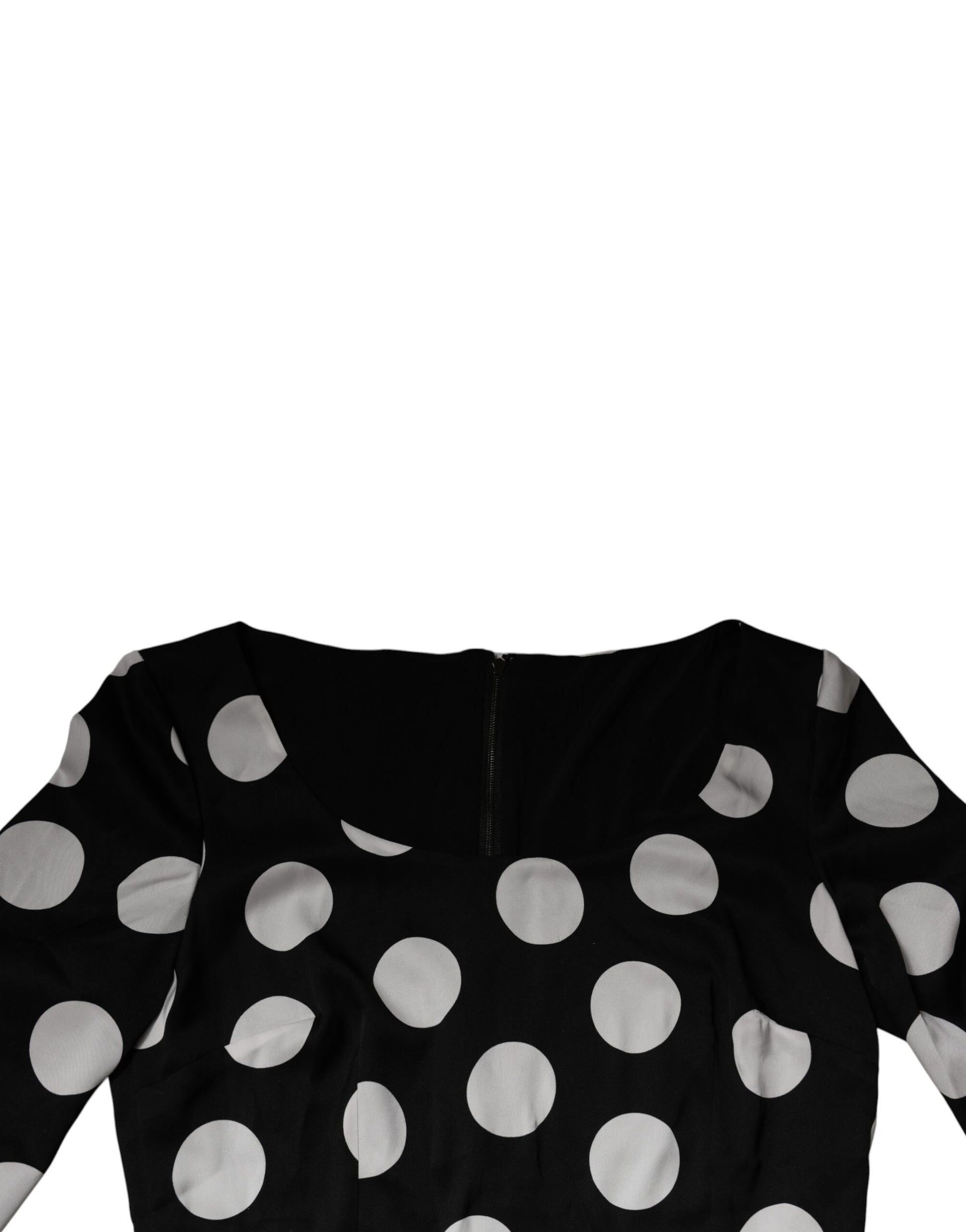 A black midi dress with white polka dots and a sheath silhouette