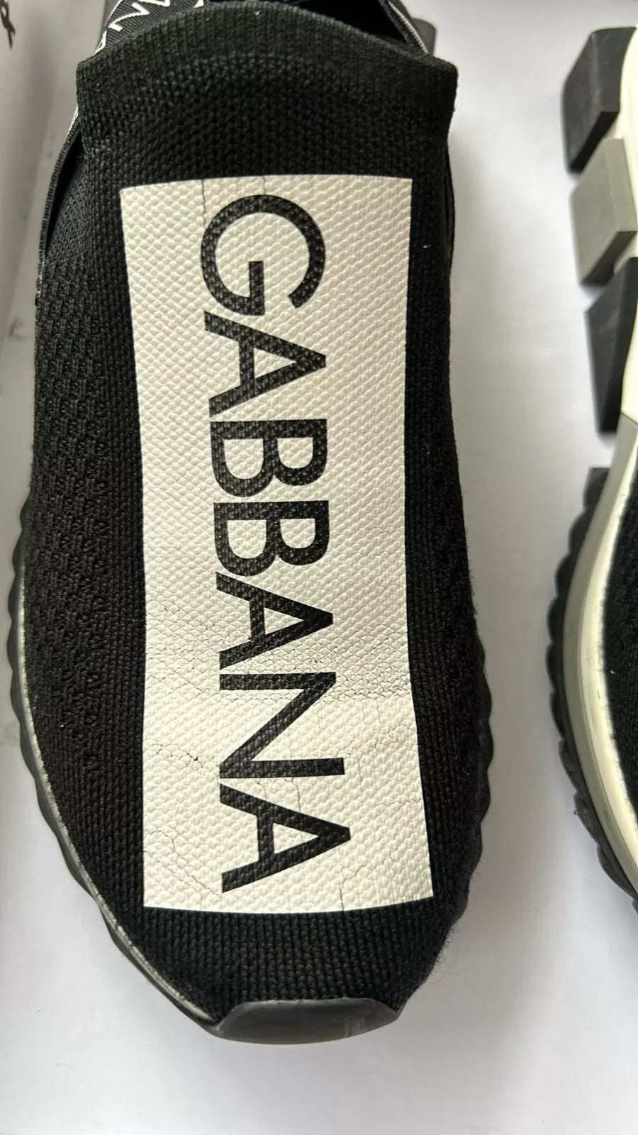 Black shoe with white label reading gabana