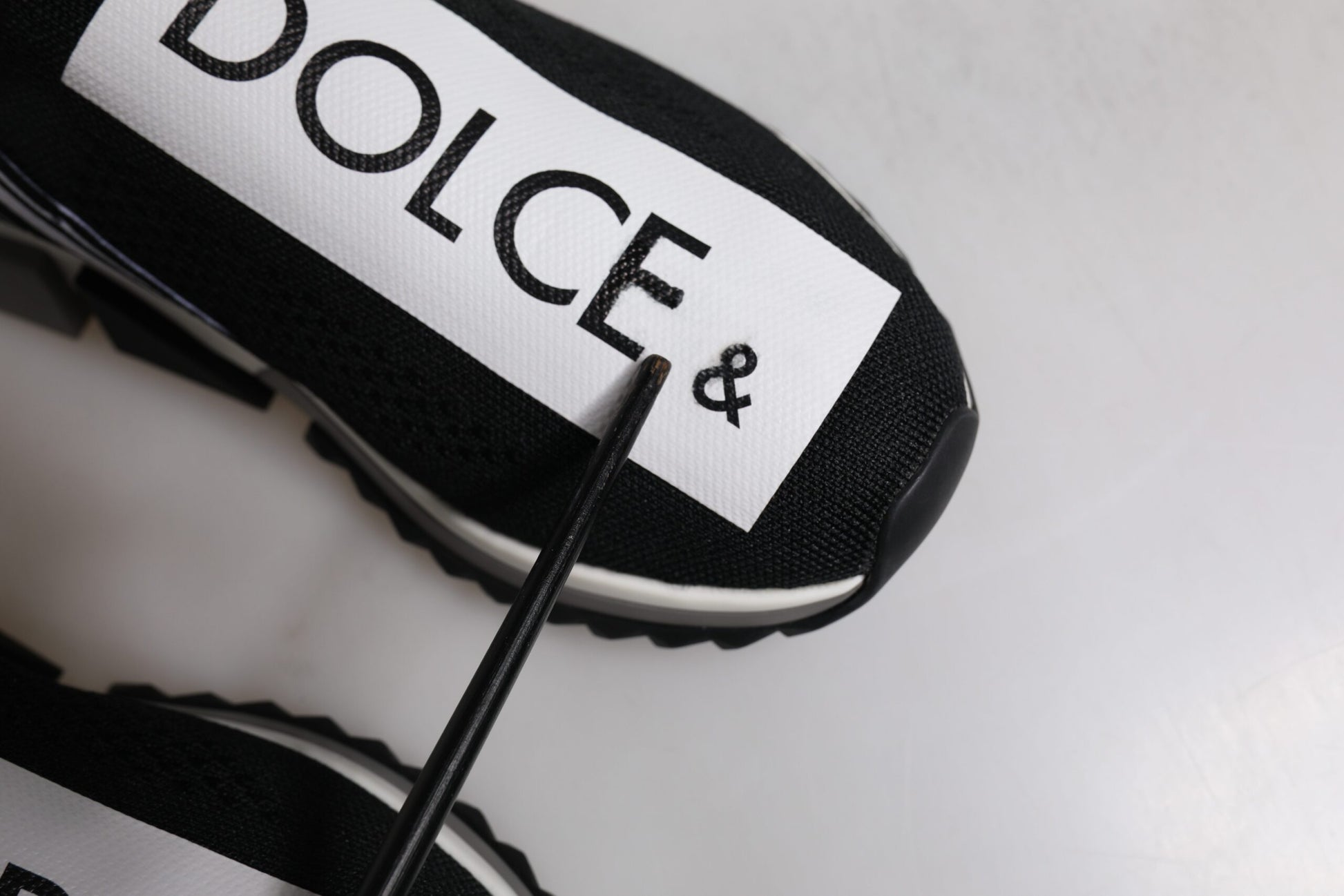 Black and white sneaker with brand name on side