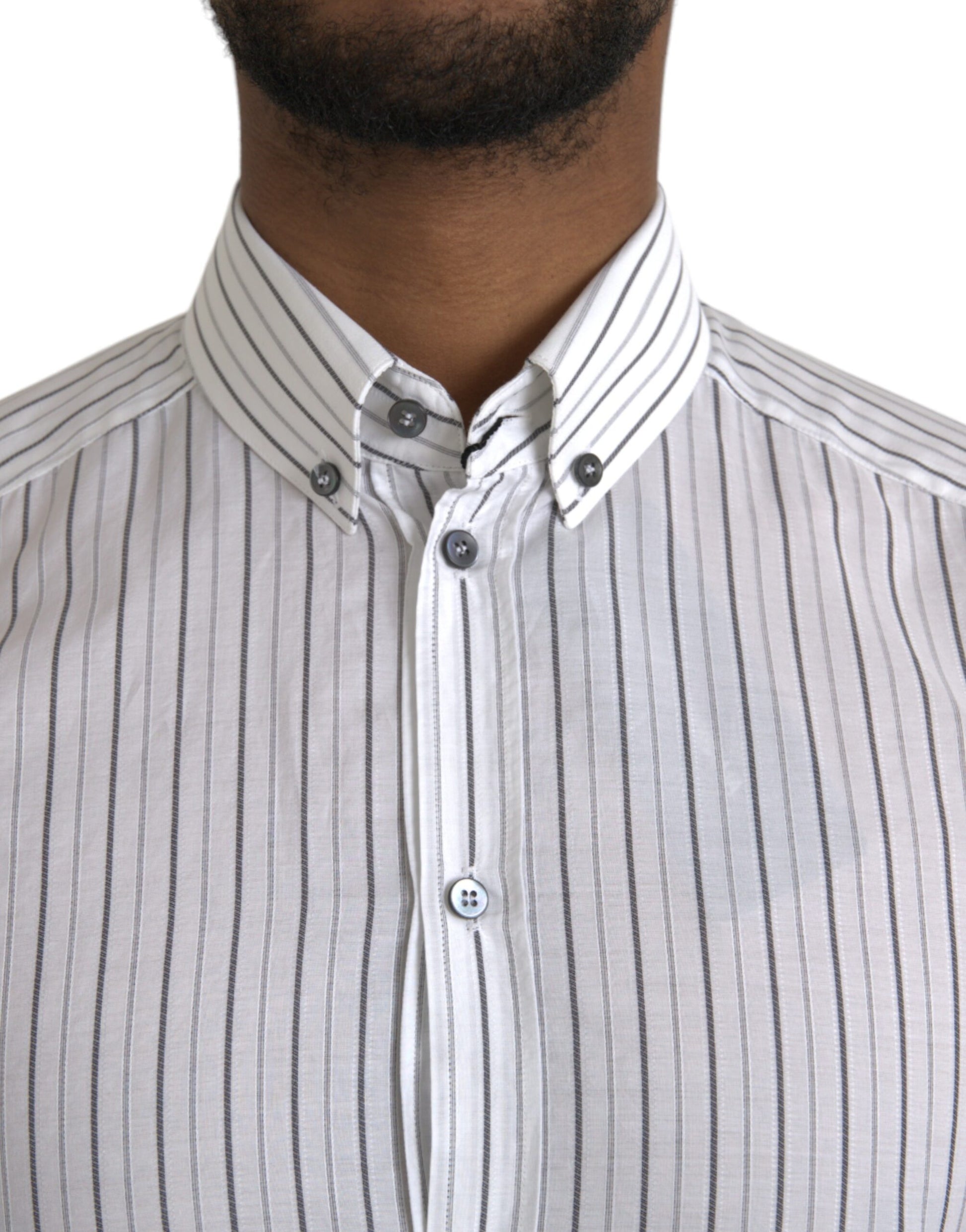 A black and white striped shirt with a gold button