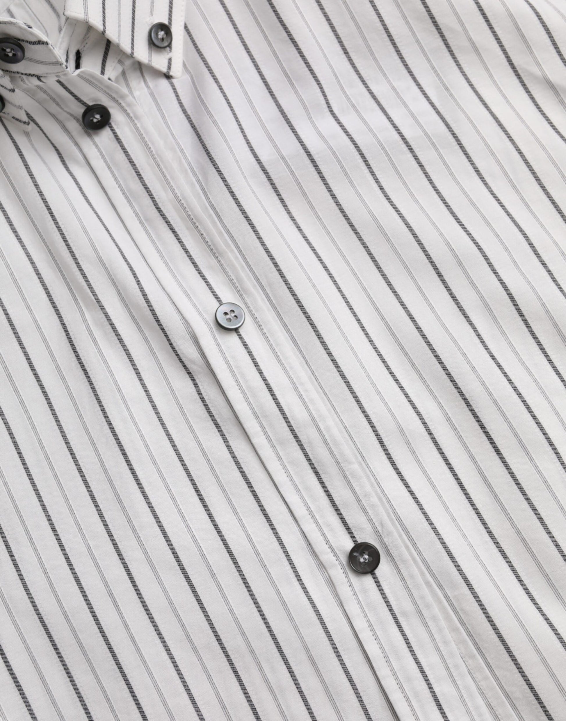 A black and white striped shirt with gold buttons