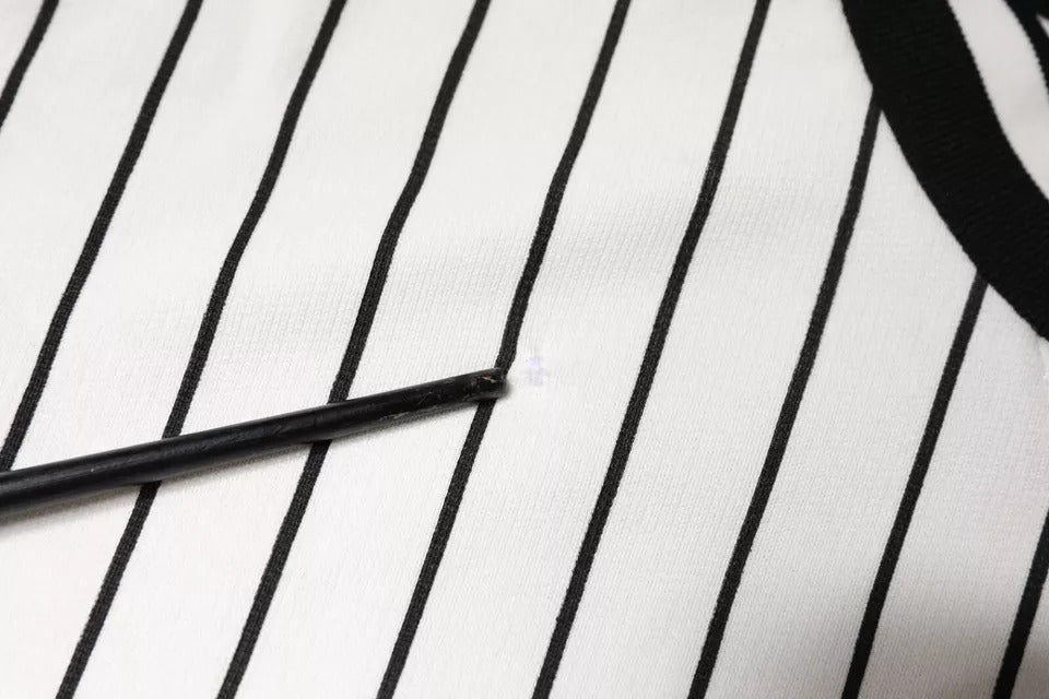 Black eyeliner pencil on black and white striped fabric