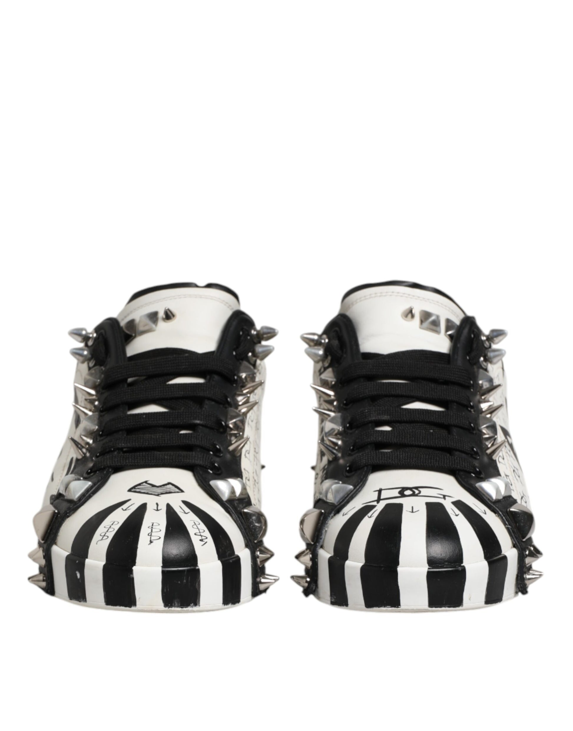 Pair of black and white studded low top sneakers with laces, featuring a unique design