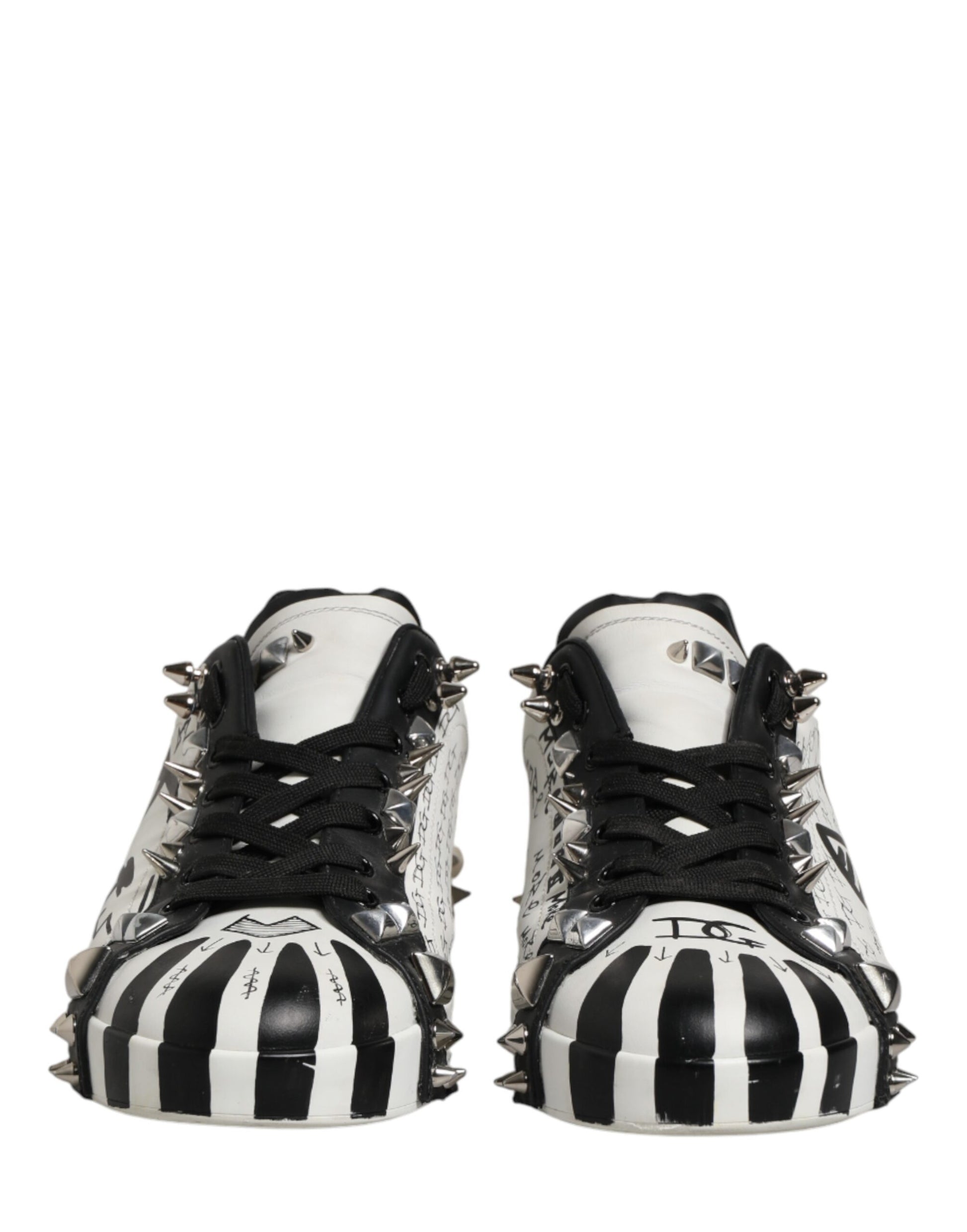 Pair of black and white striped shoes with spikes on the bottom